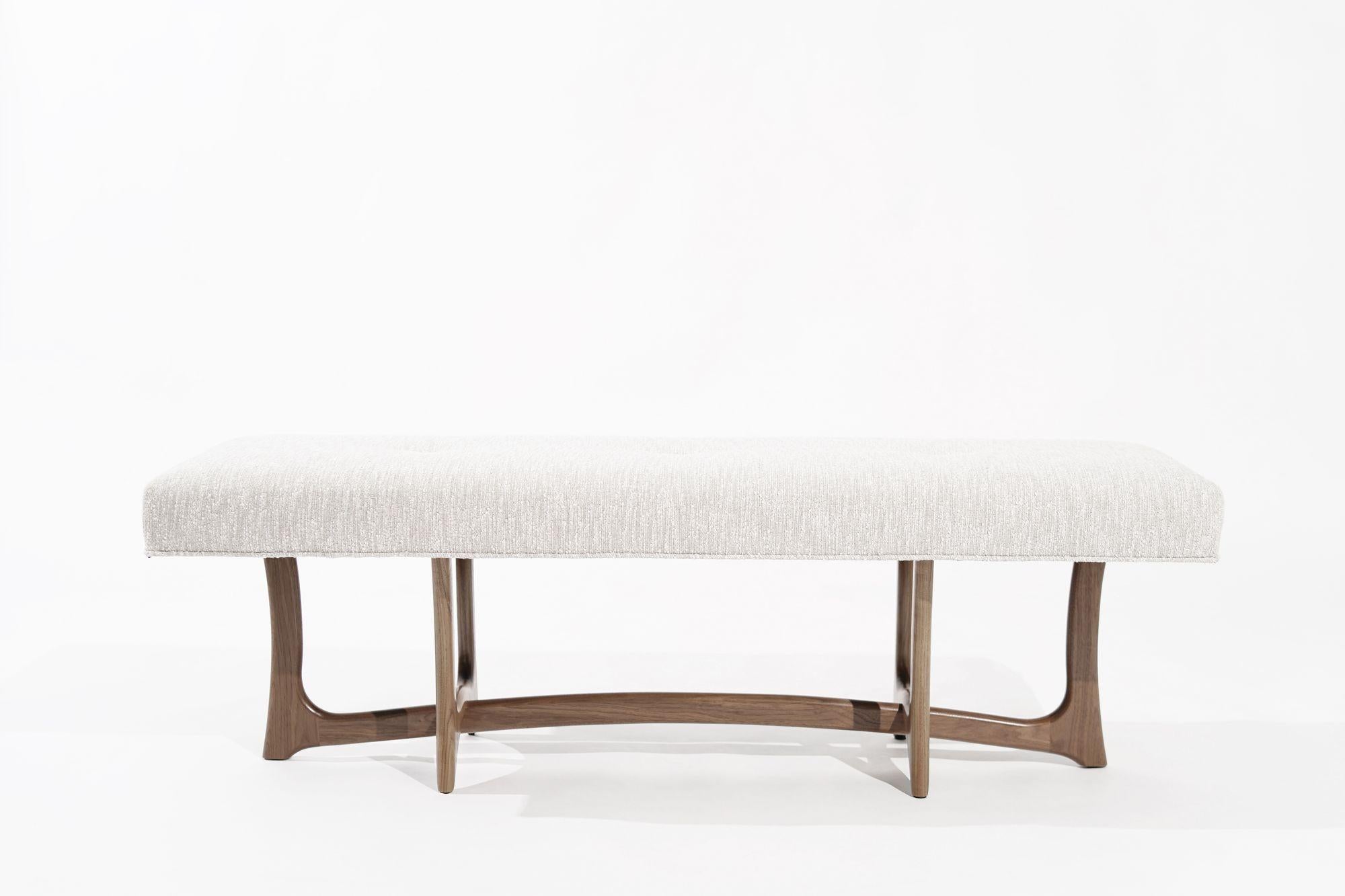 Introducing the Forma Bench by Stamford Modern—an embodiment of Mid-Century Modern elegance, seamlessly blending visionary designs by Adrian Pearsall and Vladimir Kagan. With a sculpted walnut base and plush upholstered cushion, it offers both form