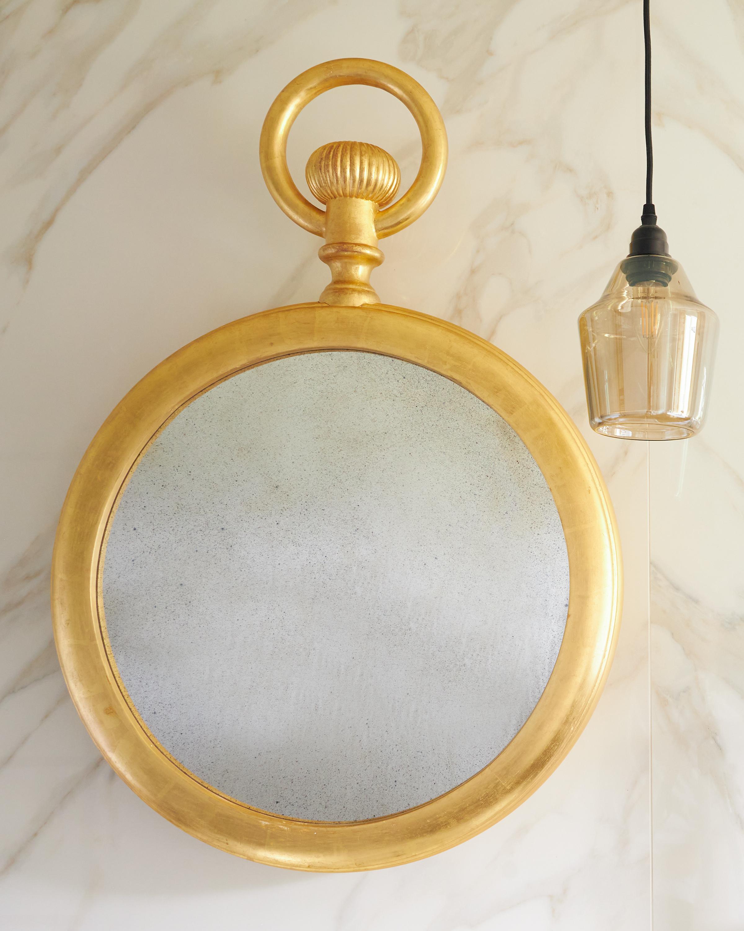 Ein feiner konvexer Spiegel aus vergoldetem Holz im Taschenuhrendesign mit Landhausproportionen in der Art von Piero Fornasetti. Geschnitzte Details, darunter der markante obere Ring der Uhr und das gedrehte Zifferblatt. Dieser große