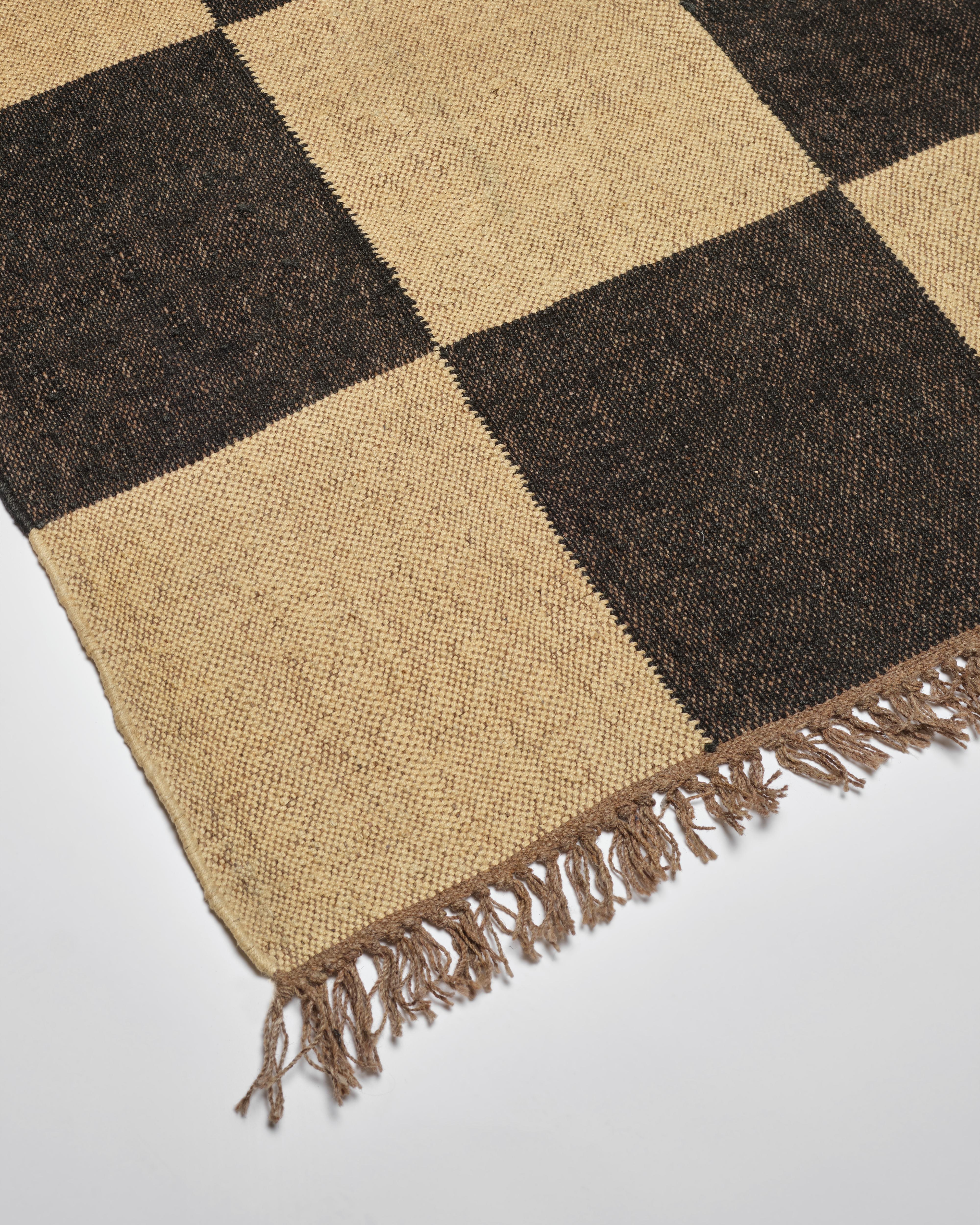 Our beautiful wool and jute checkerboard rugs are expertly handwoven in Jaipur, India. The checkerboard pattern and neutral off black & natural coloring are chic and sophisticated with a hint of bohemian cool. These bigger checks are approximately