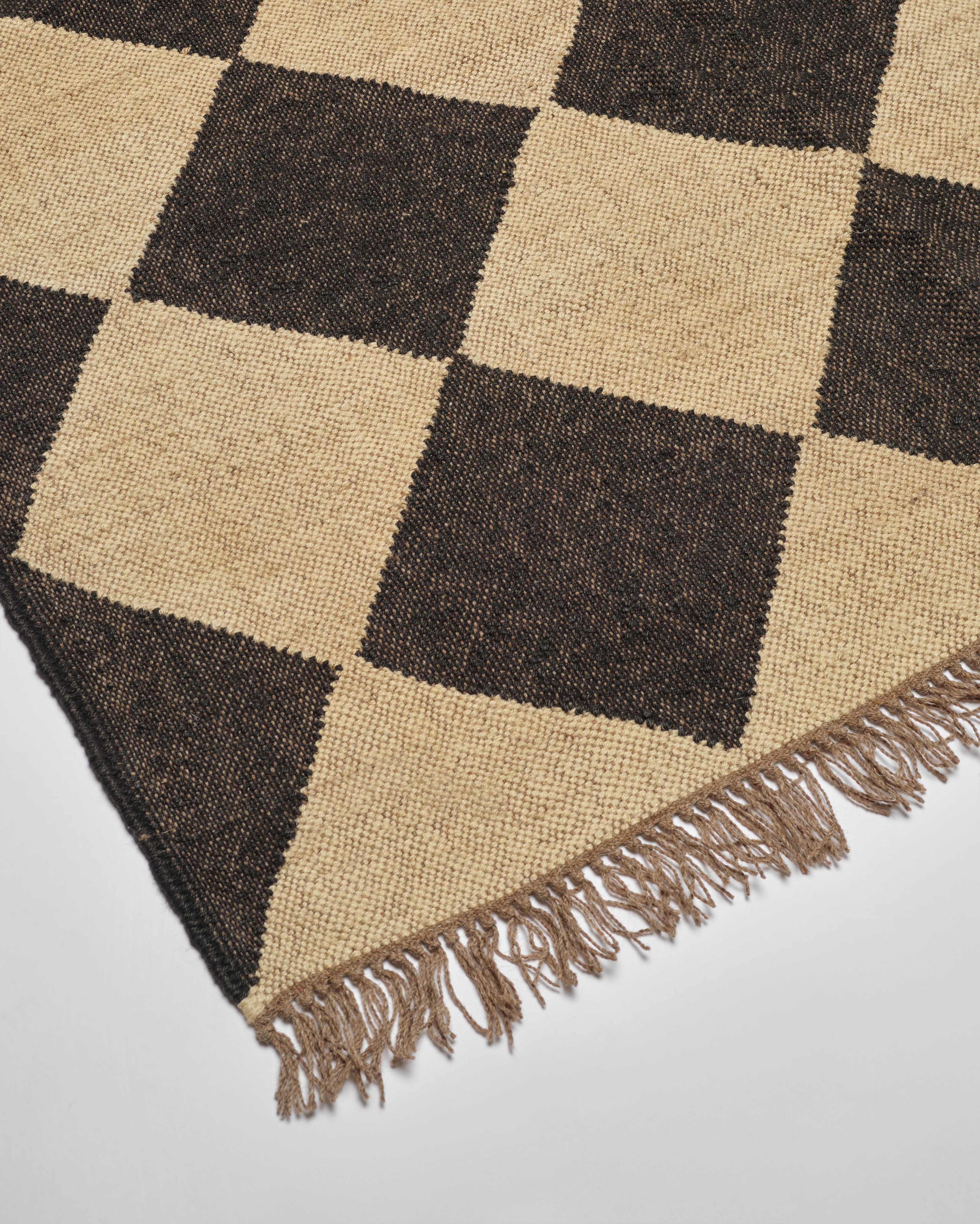 Our beautiful wool and jute checkerboard rugs are expertly handwoven in Jaipur, India. The diamond checkerboard pattern and neutral off black & natural coloring are chic and sophisticated with a hint of bohemian cool. These bigger checks are