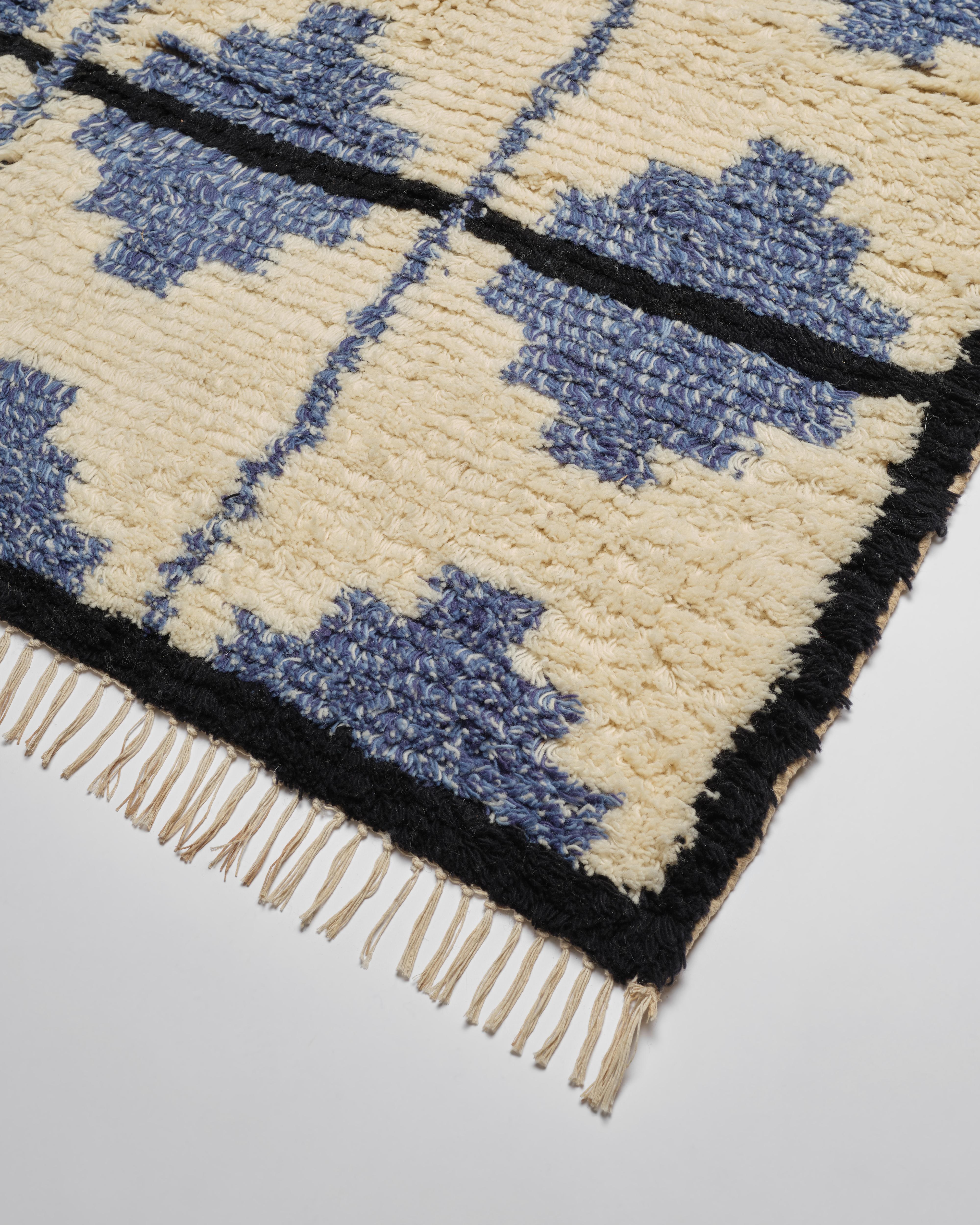 Unsere wunderschönen Teppiche aus Wolle und Baumwolle im marokkanischen Stil werden in Jaipur, Indien, fachmännisch handgeknüpft. Das Kachelmuster aus Creme, Blau und Schwarz ist schick und raffiniert mit einem Hauch von Bohème. Erhältlich in den