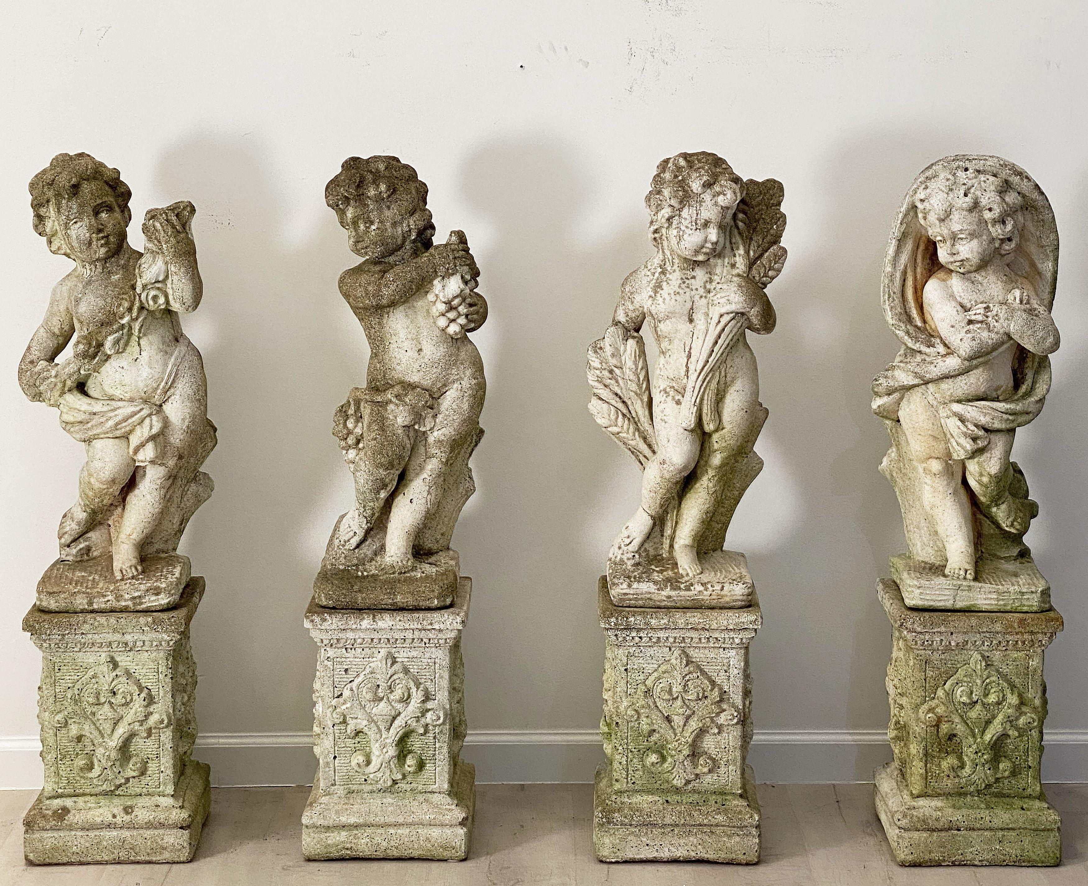A superb collection of Italian garden statuary, of composition stone, featuring finely modeled representations of the Four Seasons - Spring, Summer, Autumn, and Winter - as stylized putti or cherubs - each statue standing on a square