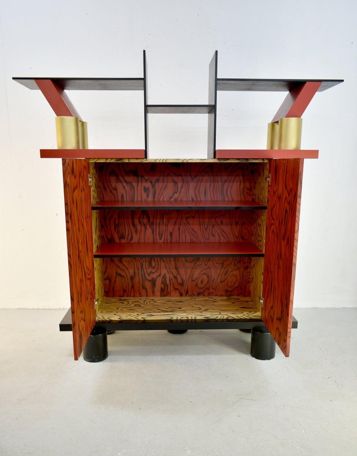Freemont cabinet, an iconic postmodern design by Ettore Sottsass for Memphis Milano

Designed in 1985, wood, plastic laminate, aluminium, and gilded wood console.

With manufacturer's metal label printed with MEMPHIS/MILANO/ETTORE