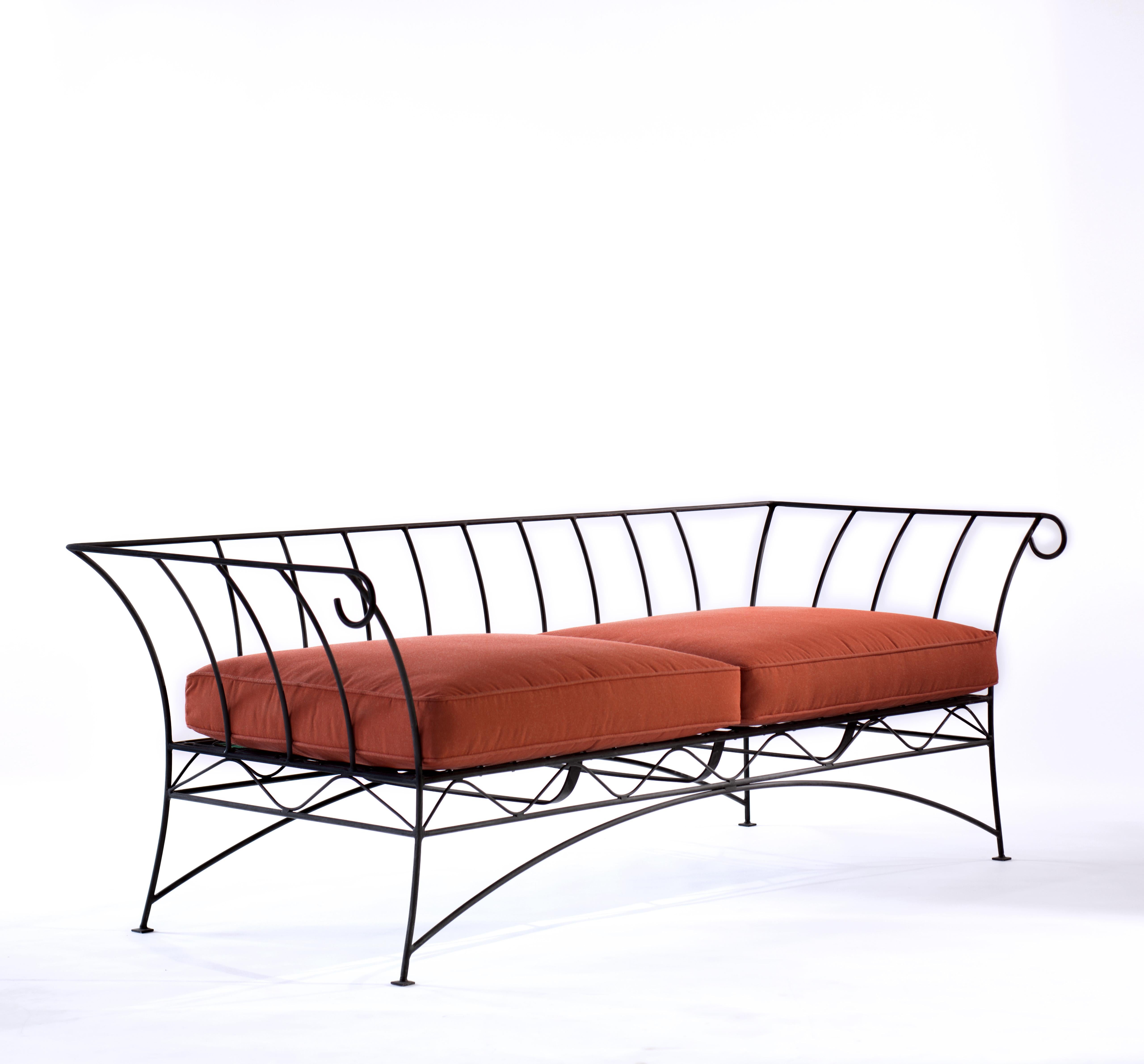 An ebonized steel frame garden sofa with water resistant cushions.
B.B - The decorative light framework holds an elasticated webbed base giving the cushions a comfortable springiness. This sofa sits well in the garden or on a terrace and also works