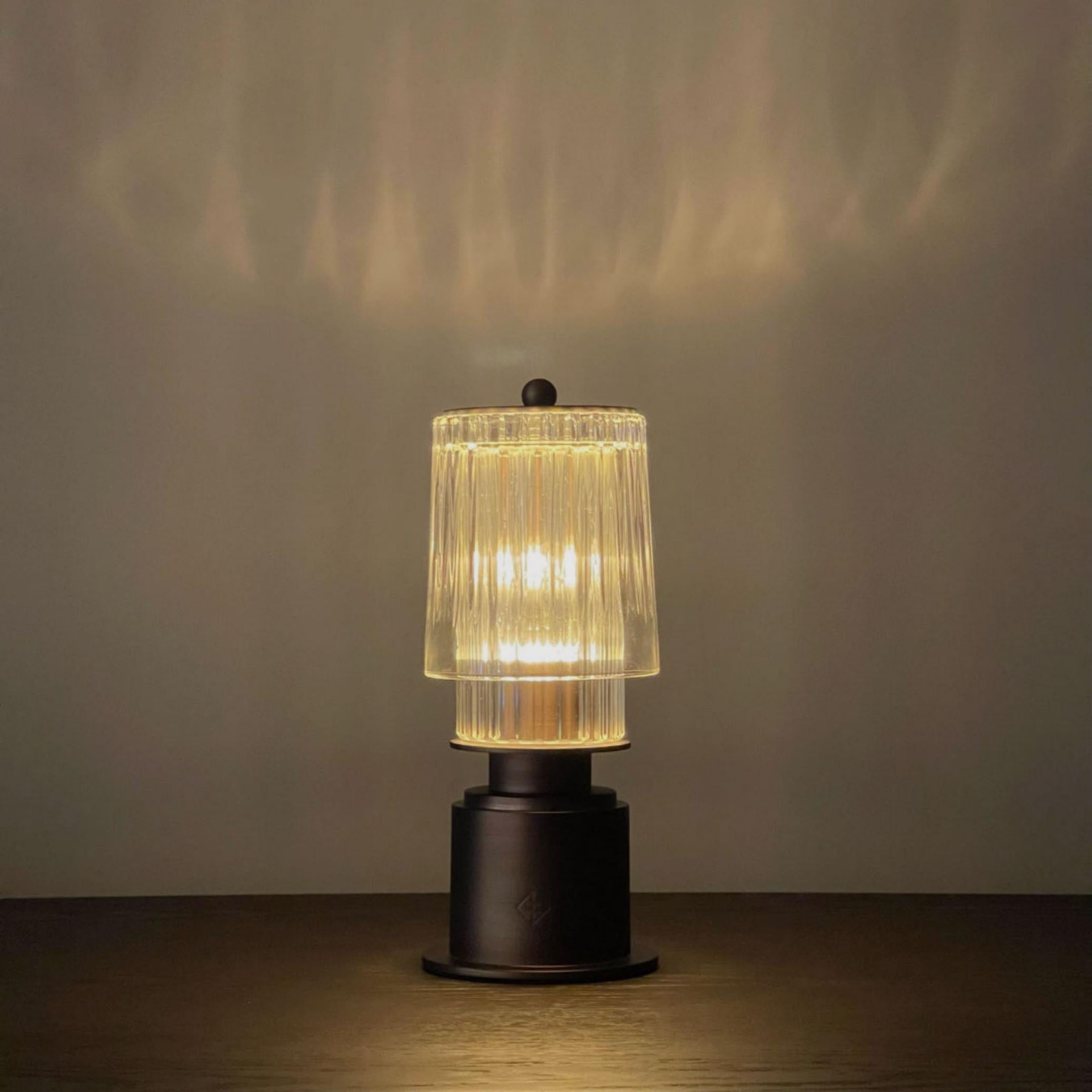 Diese handwerklich gefertigte, tragbare Lampe ist eine Neuinterpretation der klassischen Gaslaterne. Mit einer Palette aus geschliffenem Glas und eloxierter Bronze eignet sich die Lampe als Highlight für jedes Esszimmer oder als Lichtakzent in jeder