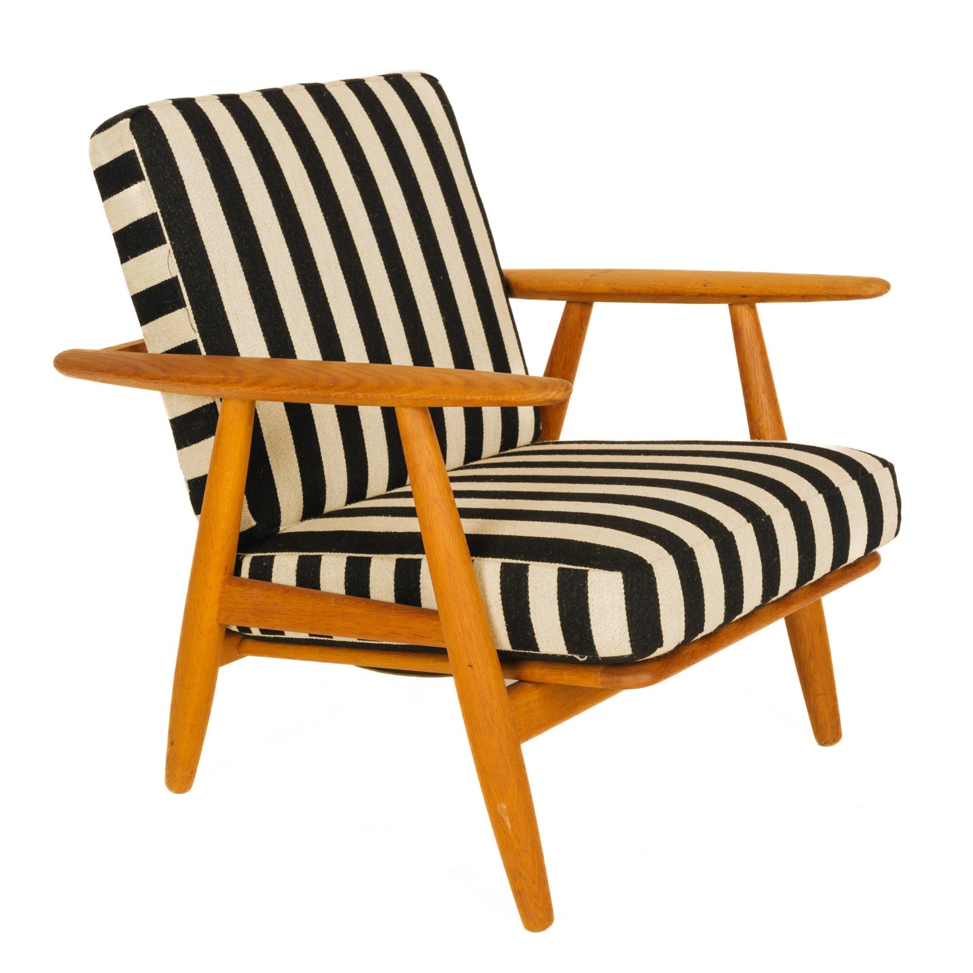 A GE 240 oak lounge chair retaining the original striped wool upholstery.