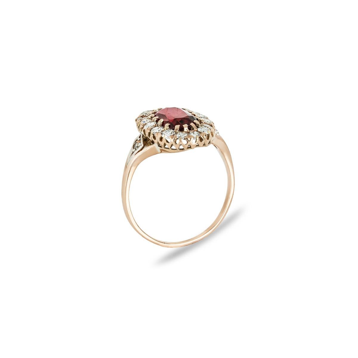 A striking 18k rose gold spinel and diamond dress ring. The ring features an unheated oval cut spinel set to the centre weighing 2.22ct and displaying a darkish red hue. Surrounding the spinel are 16 round brilliant cut diamonds set in a halo with