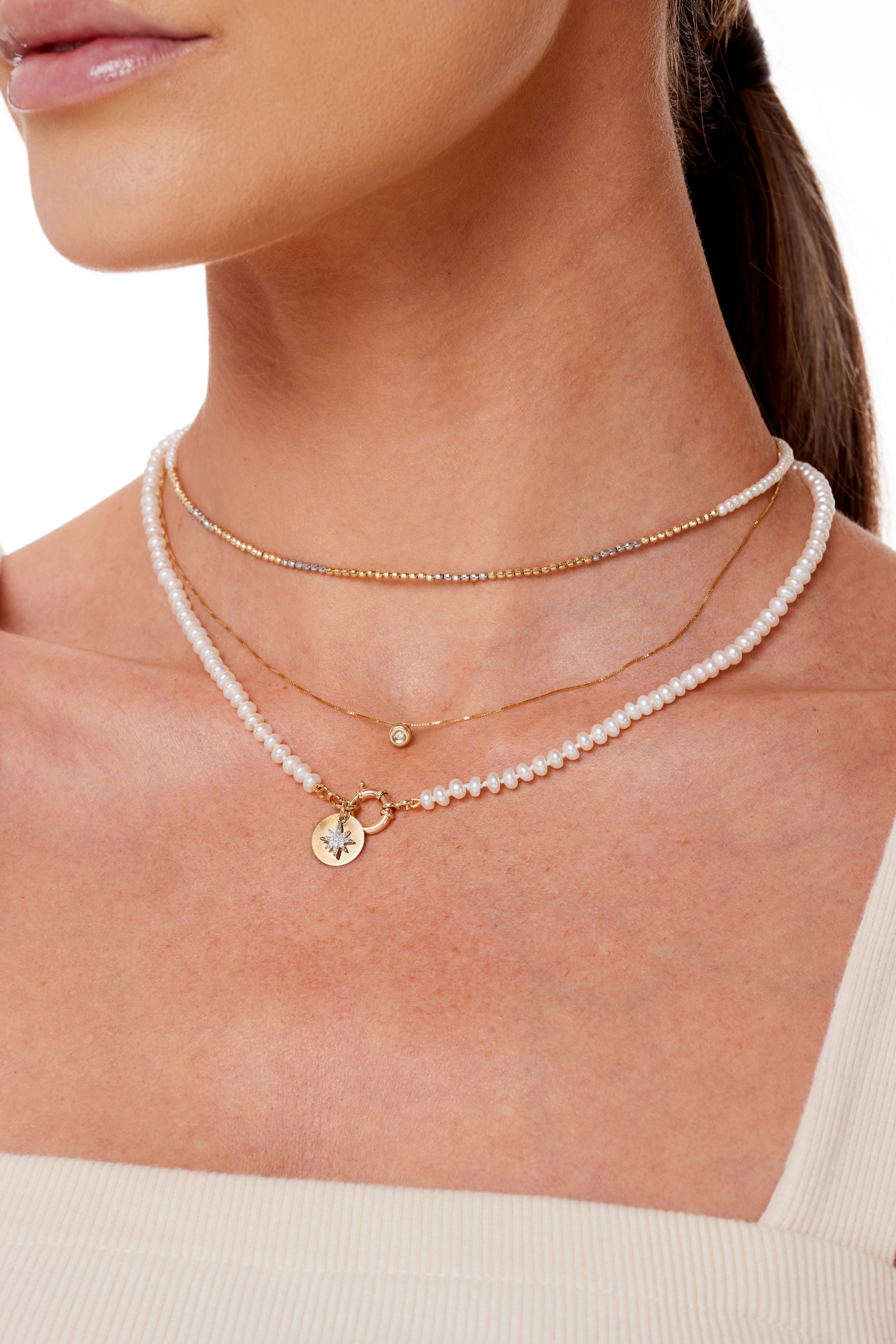 A delicate yet standout piece, this 14k faceted yellow and white Gold beads and pearl choker will sparkle across the room!  It can be worn alone or layered with another necklace to create a bolder look. Change your look and wear with the gold beads