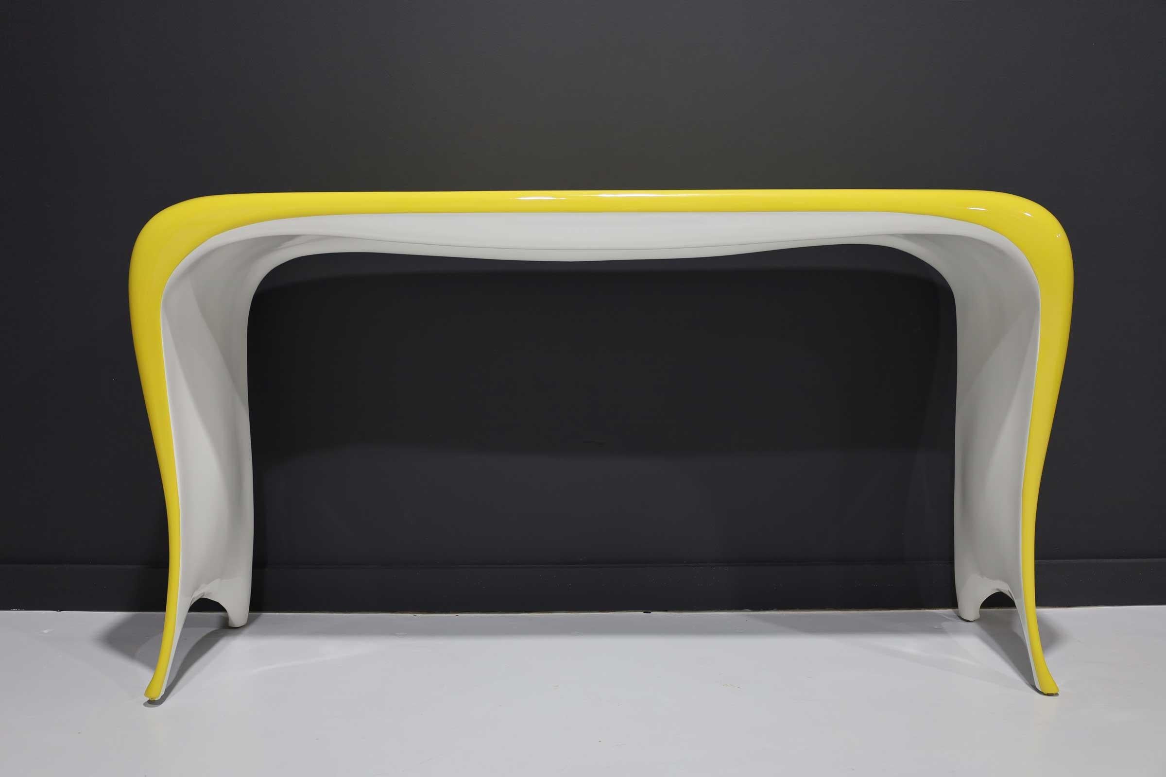 Undulating lines, soft edges and a base that appears to float, the Goddess Console by Bruce Berman. Lacquered in a high gloss yellow with a white interior.