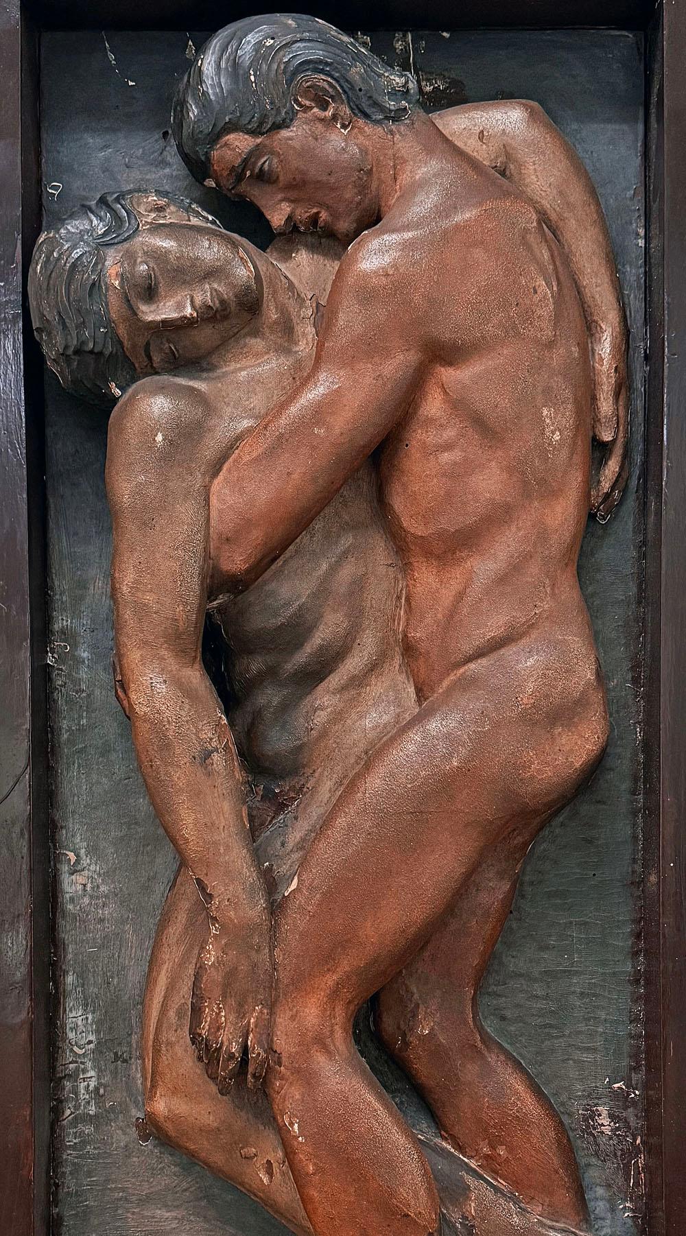 Diese bemerkenswerte und einzigartige Reliefskulptur aus geschnitztem und bemaltem Holz stellt zwei nackte männliche Figuren dar, von denen eine der anderen hilft, was möglicherweise die biblische Geschichte des barmherzigen Samariters illustriert. 