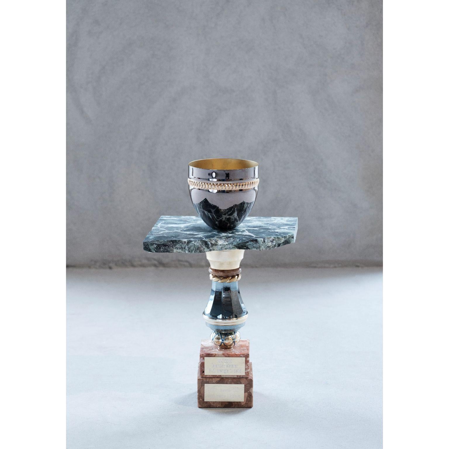 The Green marble flower pot by Flétta
Dimensions: 40 x 20 cm
Materials: green marble

Trophy is a collection of tables, lights, flowerpots and shelves made of old trophies collected from athletes and sports clubs in Iceland. Trophies are a part