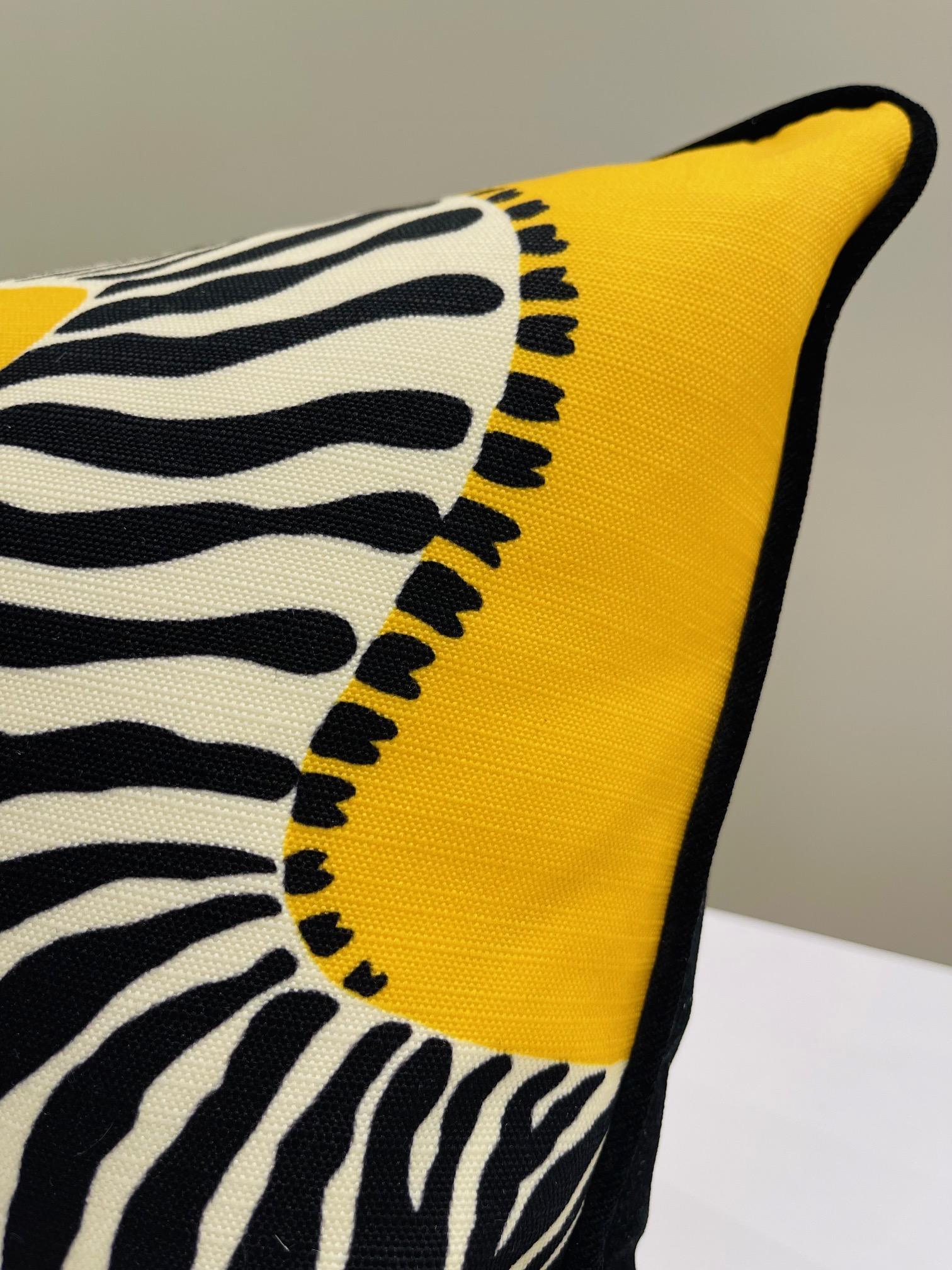 Ce luxueux oreiller en peluche est un produit de l'atelier Art by Gomez. Le devant est revêtu d'un riche jaune tournesol qui soutient un motif de zèbres galopants. Le tissu provient des archives de la luxueuse maison Scalamandre.  Le dos est en