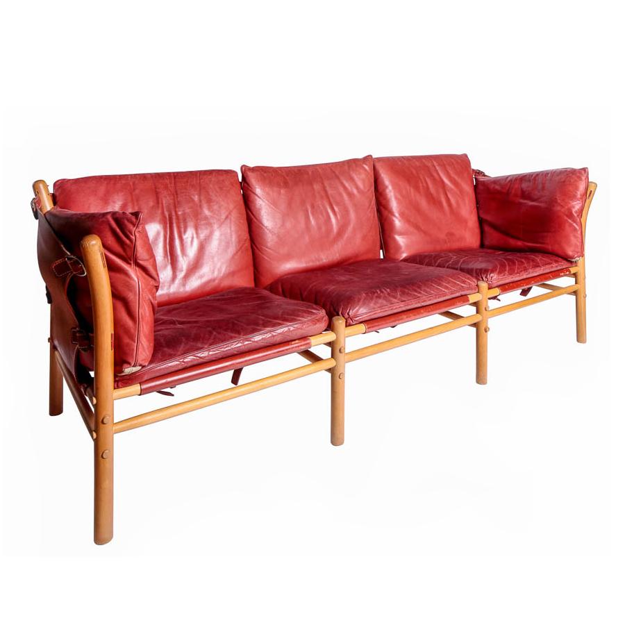Three-seat ‘Ilona’ sofa, the collapsible beech frame supported by leather straps with dull brass buckles. The original leather cushions and straps of a rare color. Designed by Swedish architect Arne Norell for Norell Möbel AB, Sweden, circa 1960s.