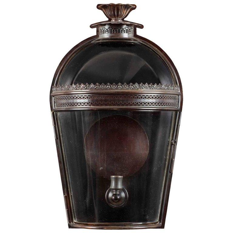 The graceful arched and glazed top with the petal shaped smoke outlet above the pierced filigree work and tapered sides makes this wall lantern both elegant and functional.