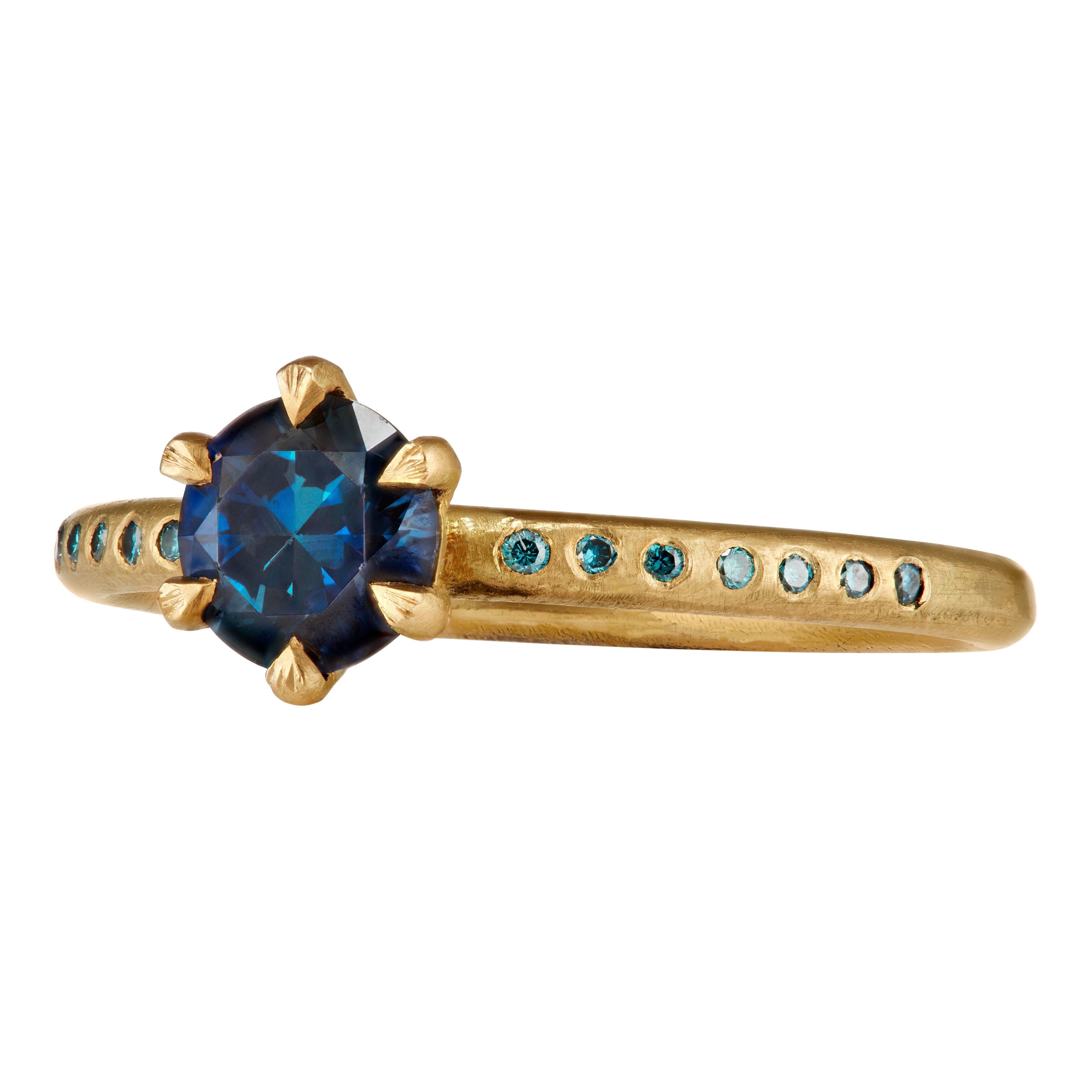 The ring’s center is a Parti blue/green sapphire of 0.75 carats. I have added fourteen turquoise diamonds to the band, giving the prong ring a thoroughly modern make-over.  

The band is round with slight hammer 1.95 mm diameter x 1.75 mm