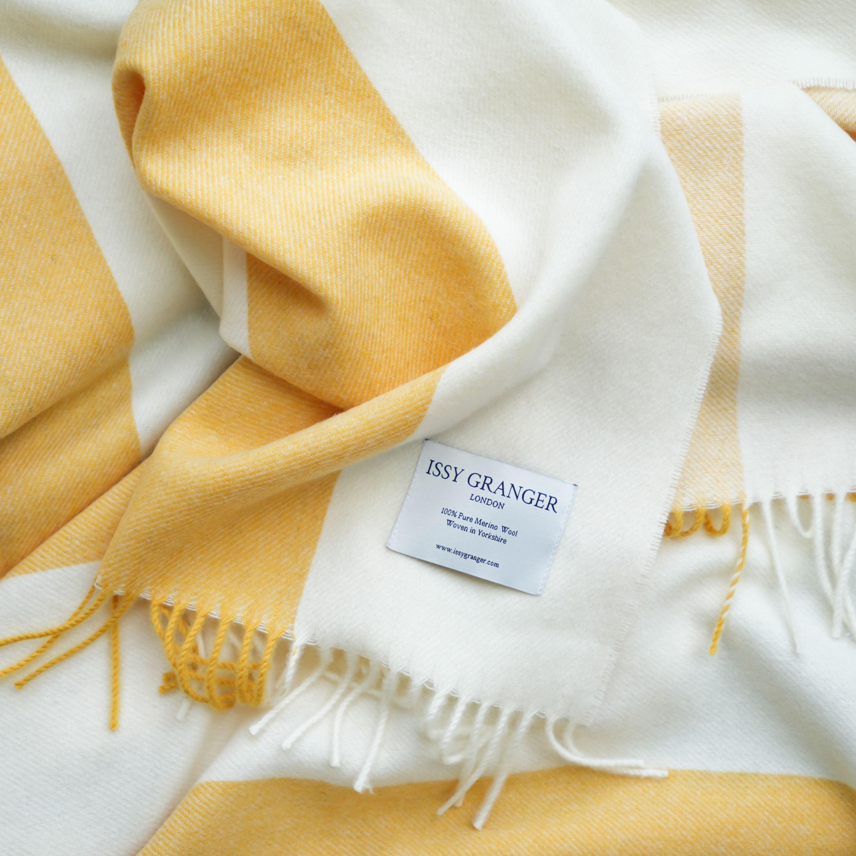 The Keats Throw is woven in beautifully soft 100% pure Merino lambswool and features a thick yellow and neutral stripe design with twisted fringing. This golden coloured blanket is lightweight, yet wonderfully warm making it a perfect and luxurious