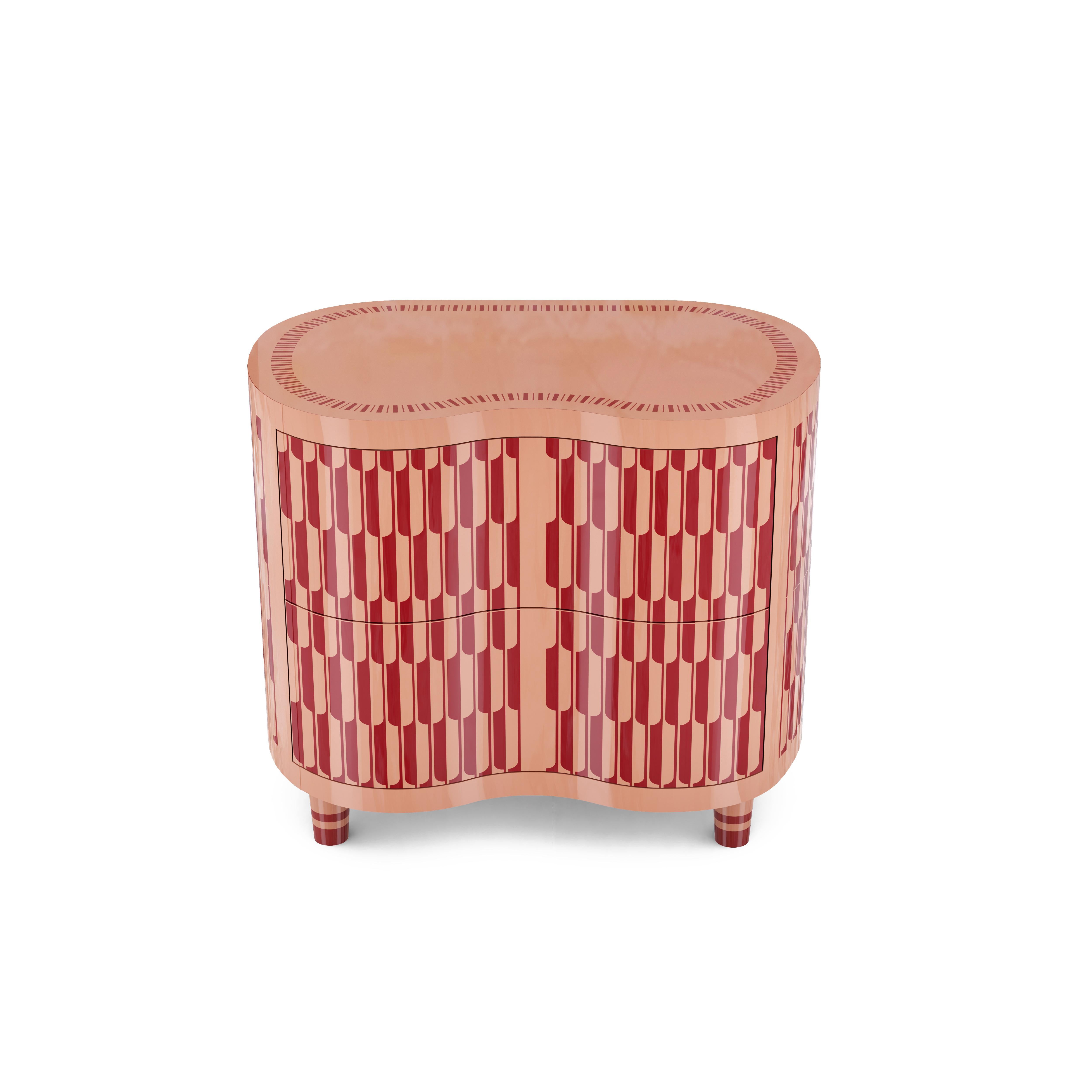 The Kid peach is a dainty night or bedside table in peach, complete with two deep drawers for storage. It is finished in peach and red resin inlay