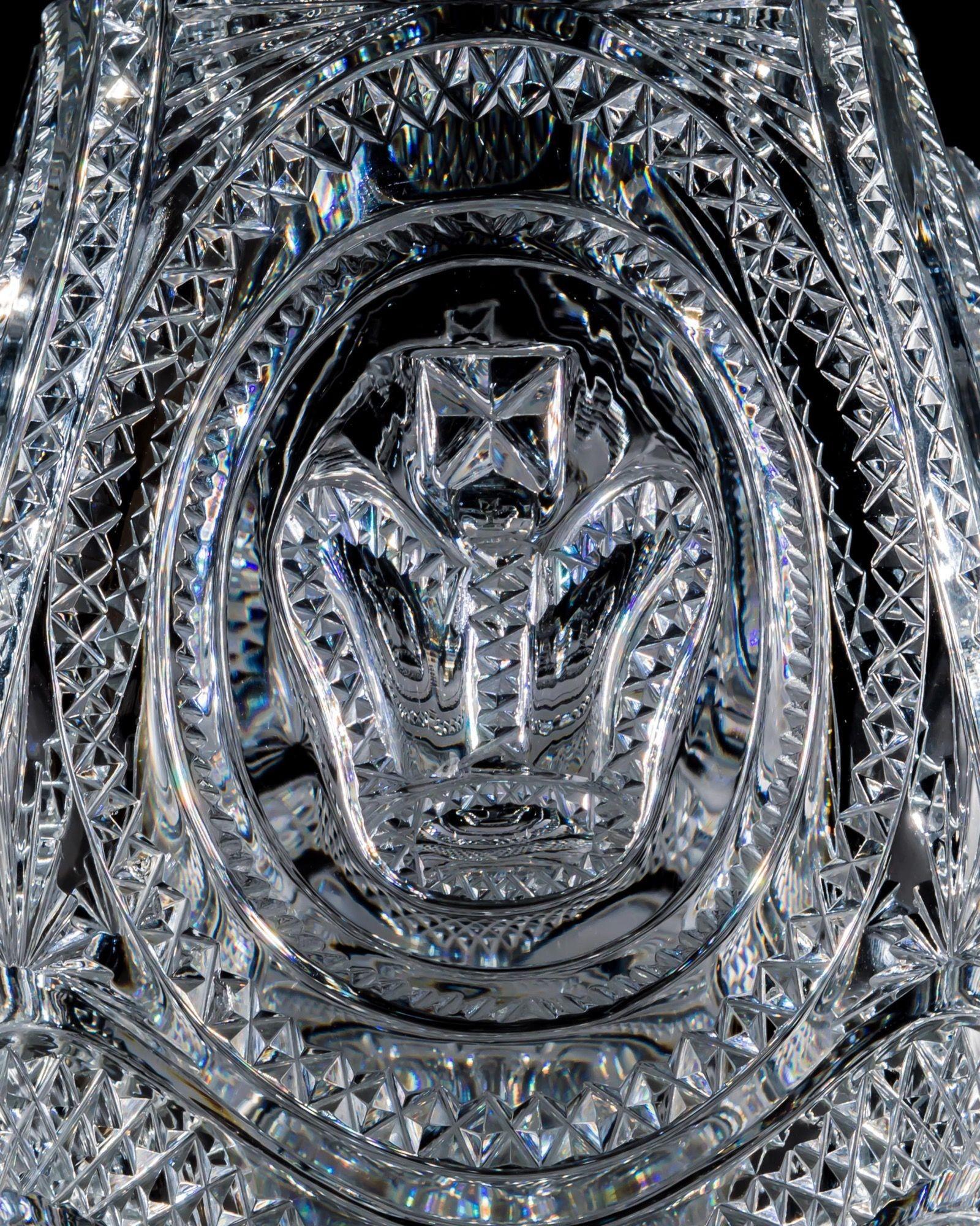 Questo eccezionale decanter in vetro soffiato e tagliato è l'apice del taglio regency. La base è decorata con sedici piume di struzzo, disposte intorno a un anello di diamanti. Il corpo è impreziosito da fasce di diamanti fini, intorno a quattro