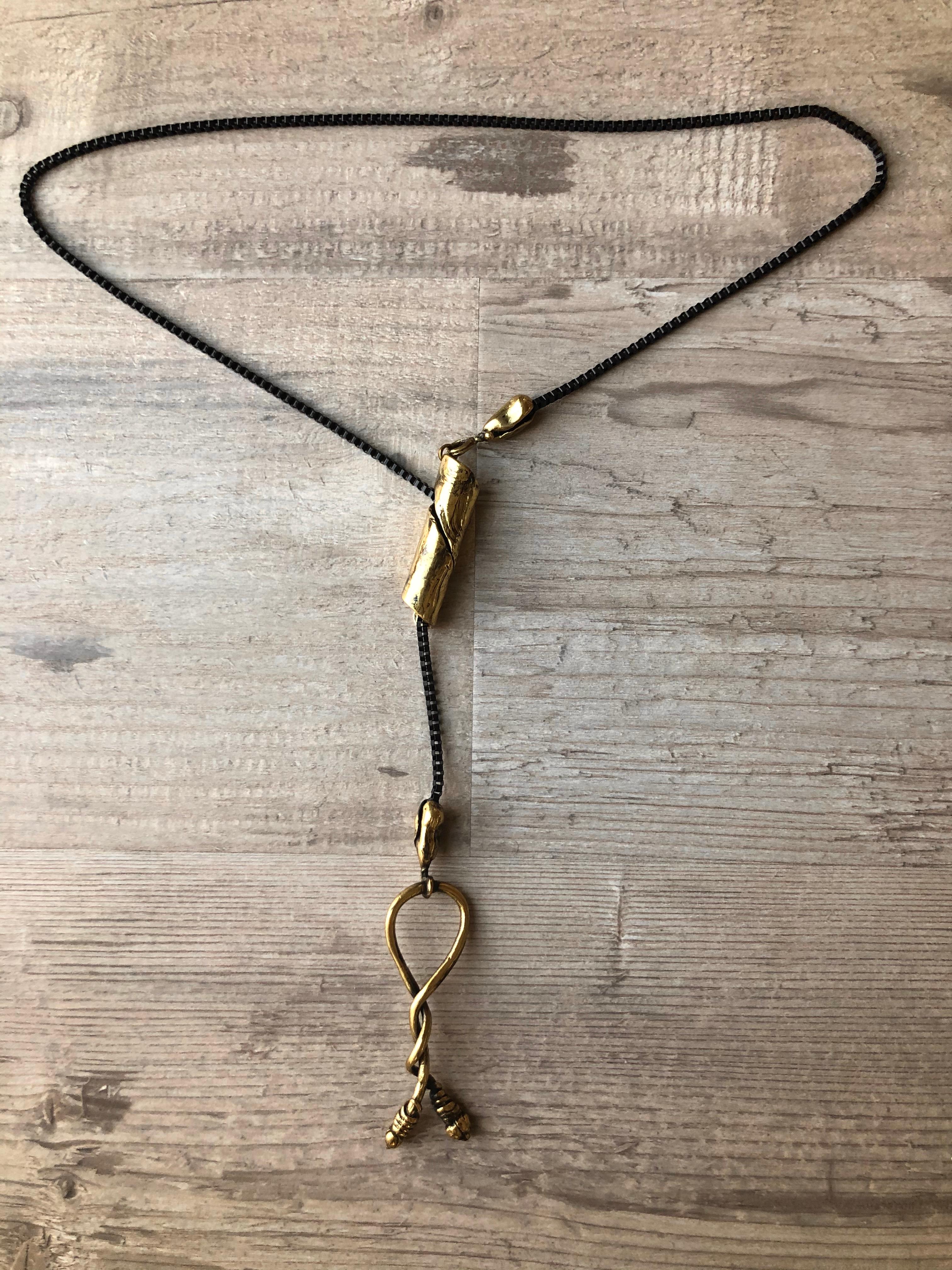 Inspired by the Knot which has the recurring theme of love and commitment. The intricate details of ancient Greek jewelry making, this dramatically long bronze pendant reveals the hand of the artist with its hand-forged texture and dainty and soft