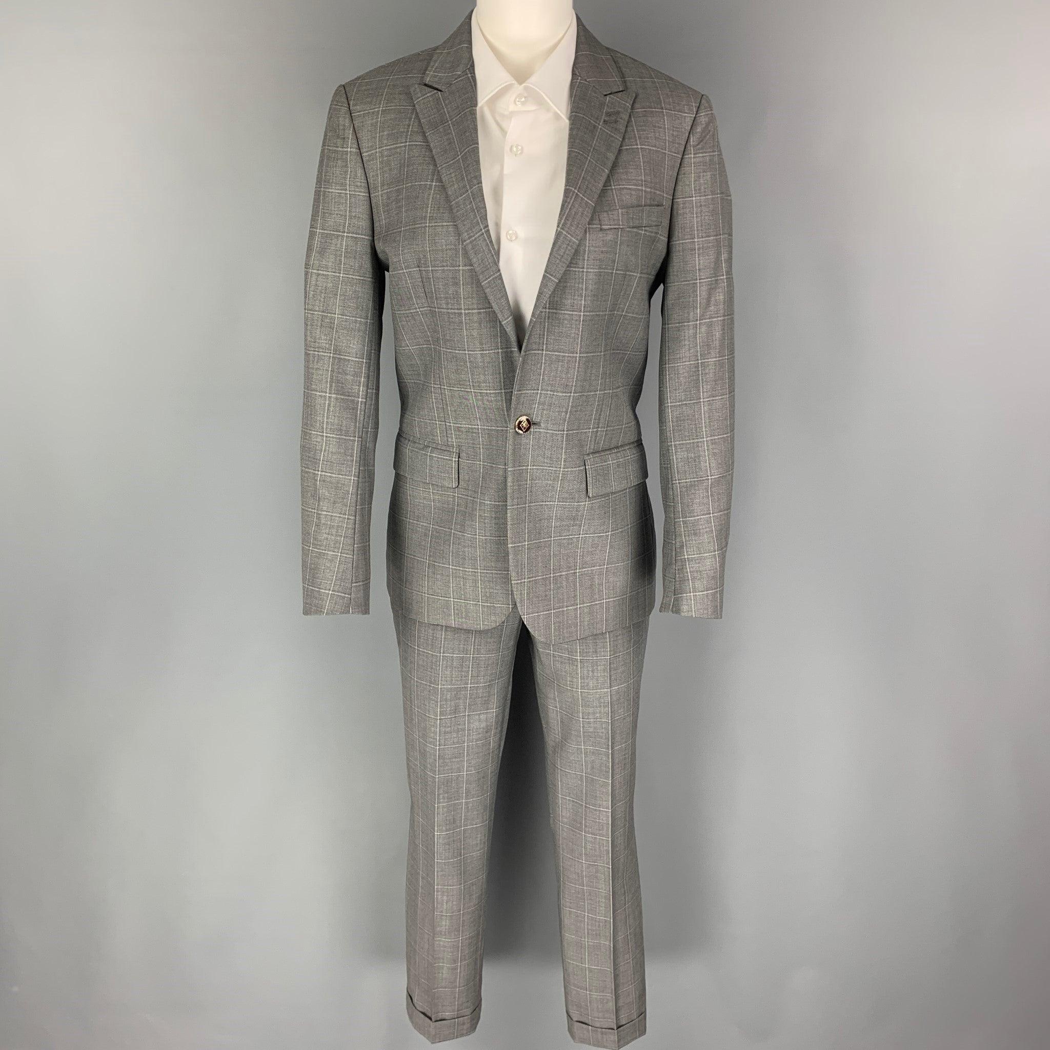 THE KOOPLES
suit comes in a grey window pane wool with a full liner and includes a single breasted, single button sport coat with a peak lapel and matching flat front trousers. Excellent Pre-Owned Condition. 

Marked:   44 

Measurements: 
 