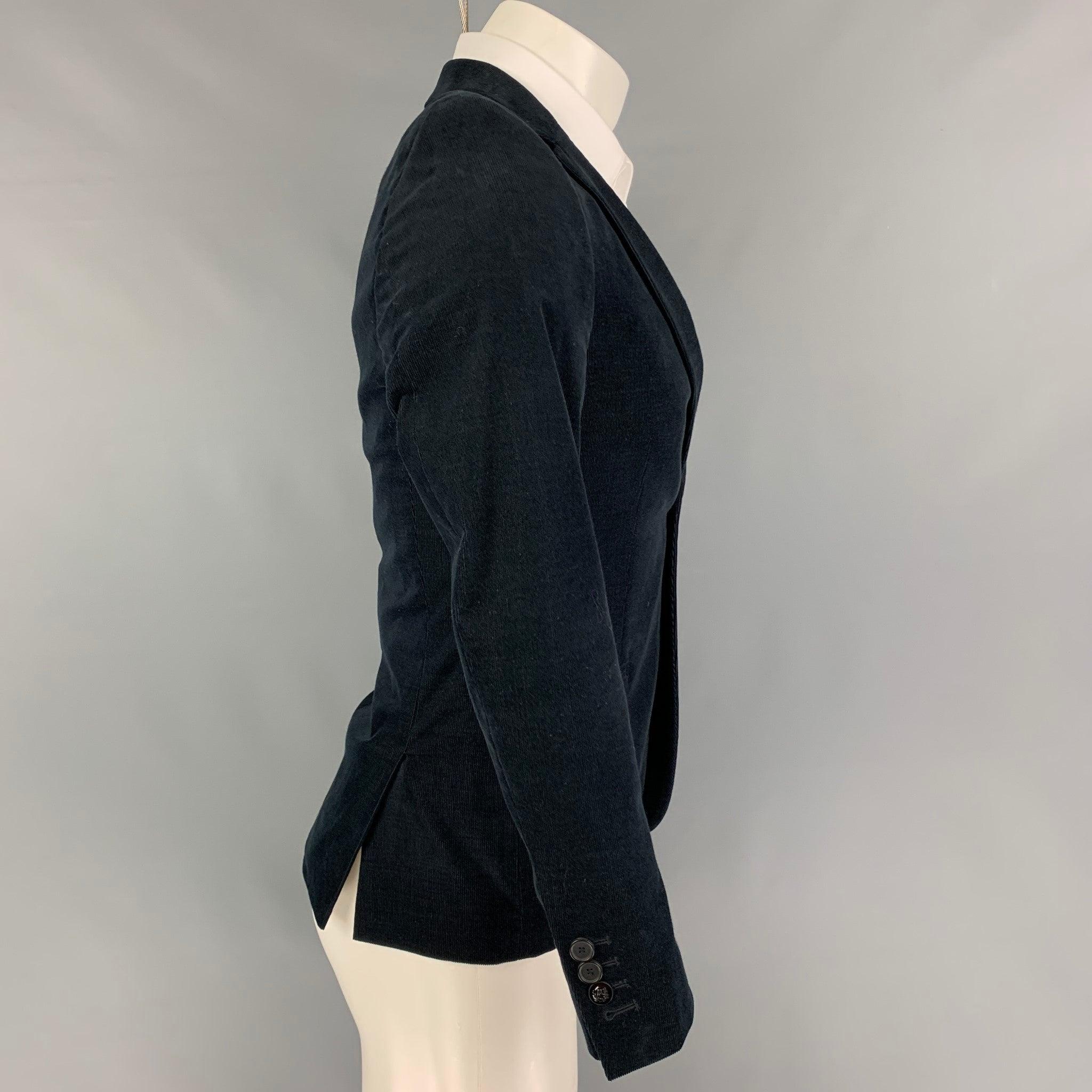 THE KOOPLES sport coat comes in a navy corduroy cotton with a full liner featuring a notch lapel, slit pockets, double back vent, and a double button closure.
Very Good
Pre-Owned Condition. 

Marked:   44 

Measurements: 
 
Shoulder: 16 inches 