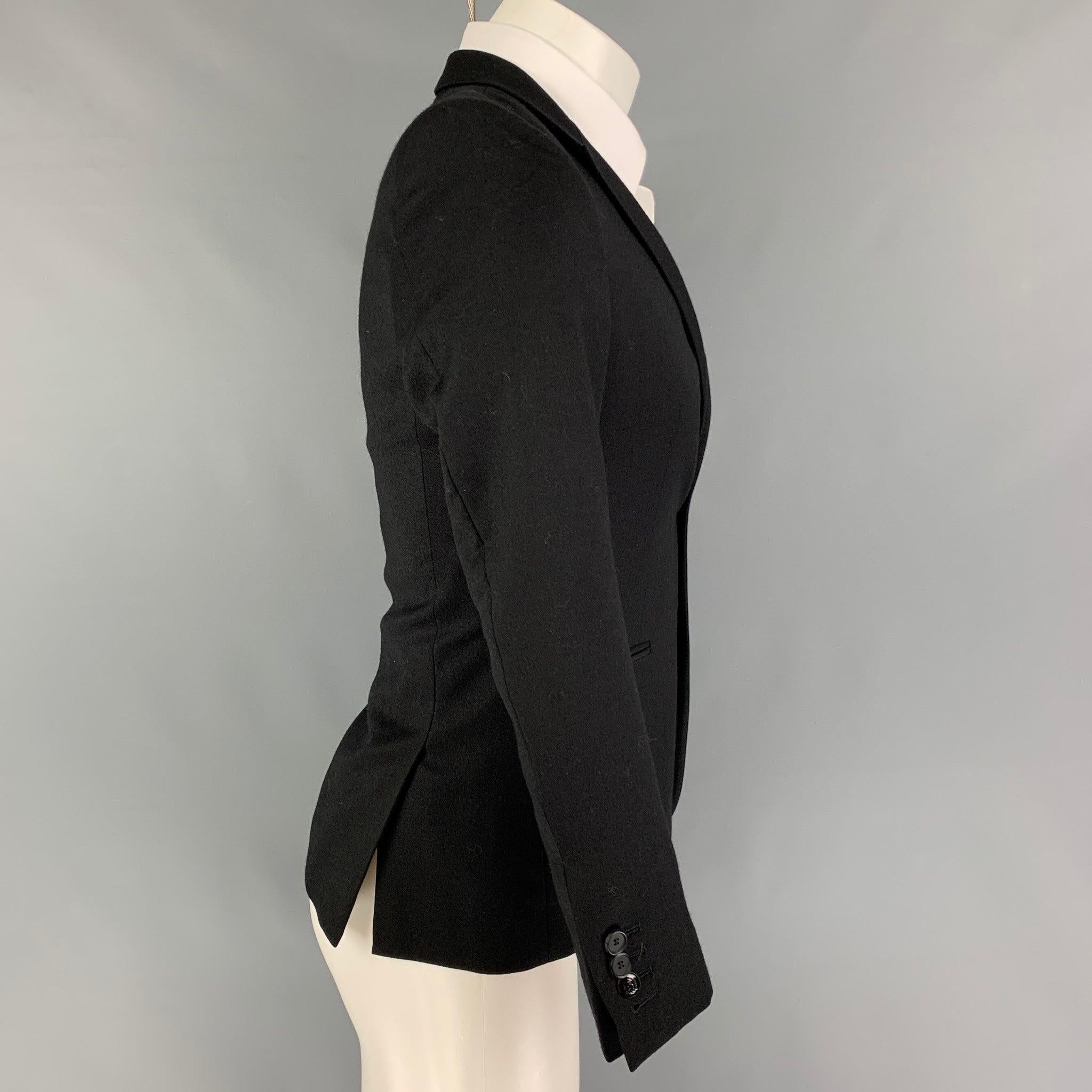 THE KOOPLES sport coat comes in a black wool featuring a peak lapel, slit pockets, double back vent, and double button closure.
Very Good
Pre-Owned Condition. 

Marked:   44 

Measurements: 
 
Shoulder: 15.5 inches  Chest: 36 inches  Sleeve: 24.5