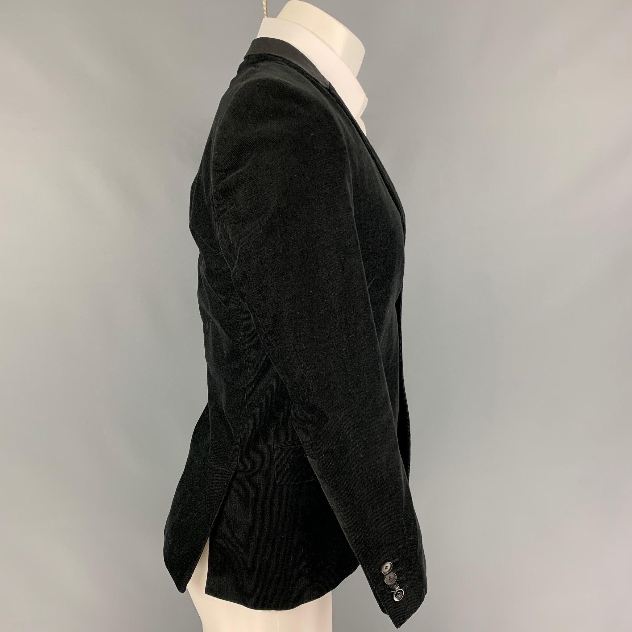 THE KOOPLES sport coat comes ina 
black corduroy cotton with a full liner featuring a notch lapel, leather trim, flap pockets, double back vent, and a double button closure.
Very Good
Pre-Owned Condition. 

Marked:   46 

Measurements: 
 
Shoulder: