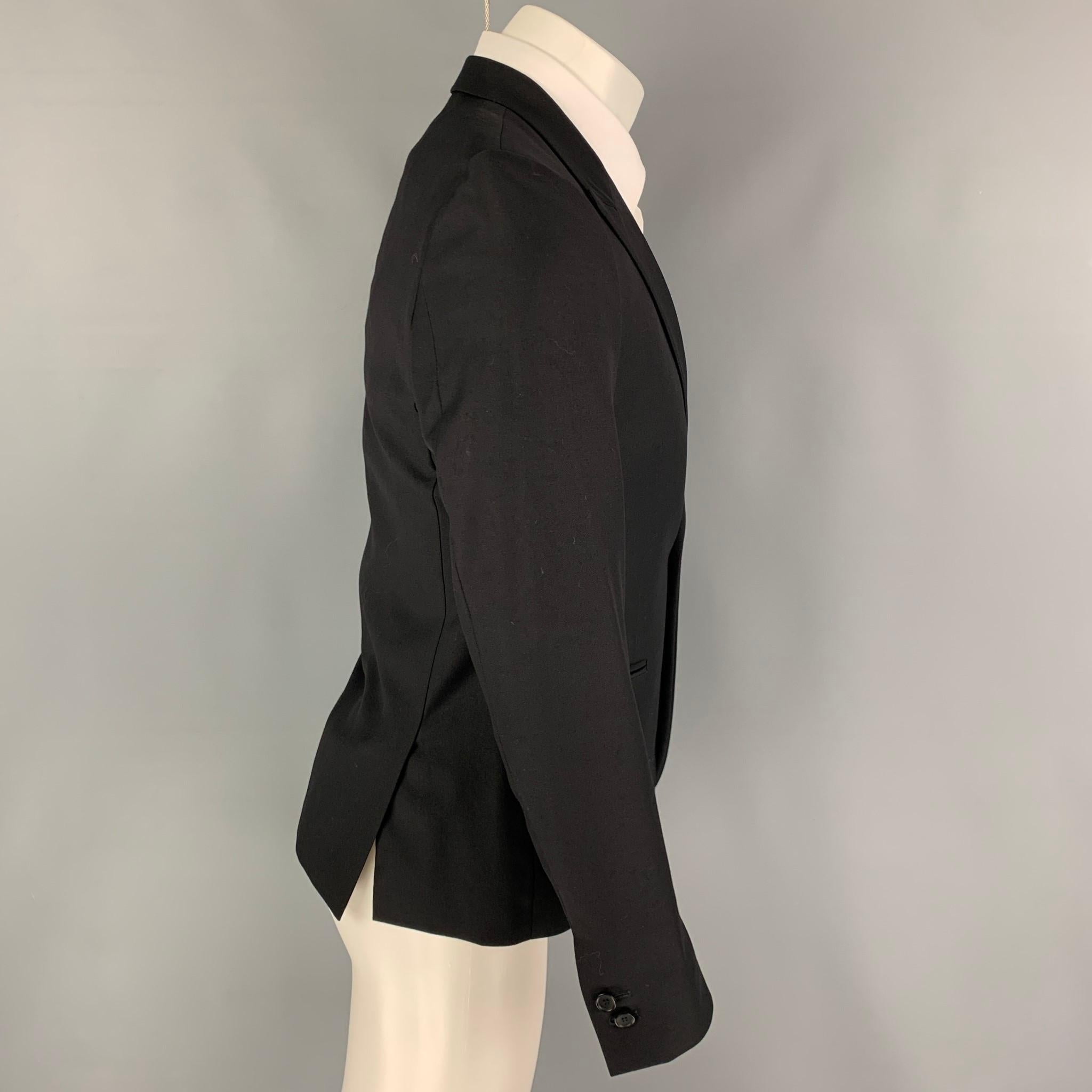 THE KOOPLES sport coat comes in a black wool with a full liner featuring a peak lapel, slit pockets, double back vent, and a single button closure. 

Excellent Pre-Owned Condition.
Marked: 46

Measurements:

Shoulder: 16 in.
Chest: 36 in.
Sleeve: 25