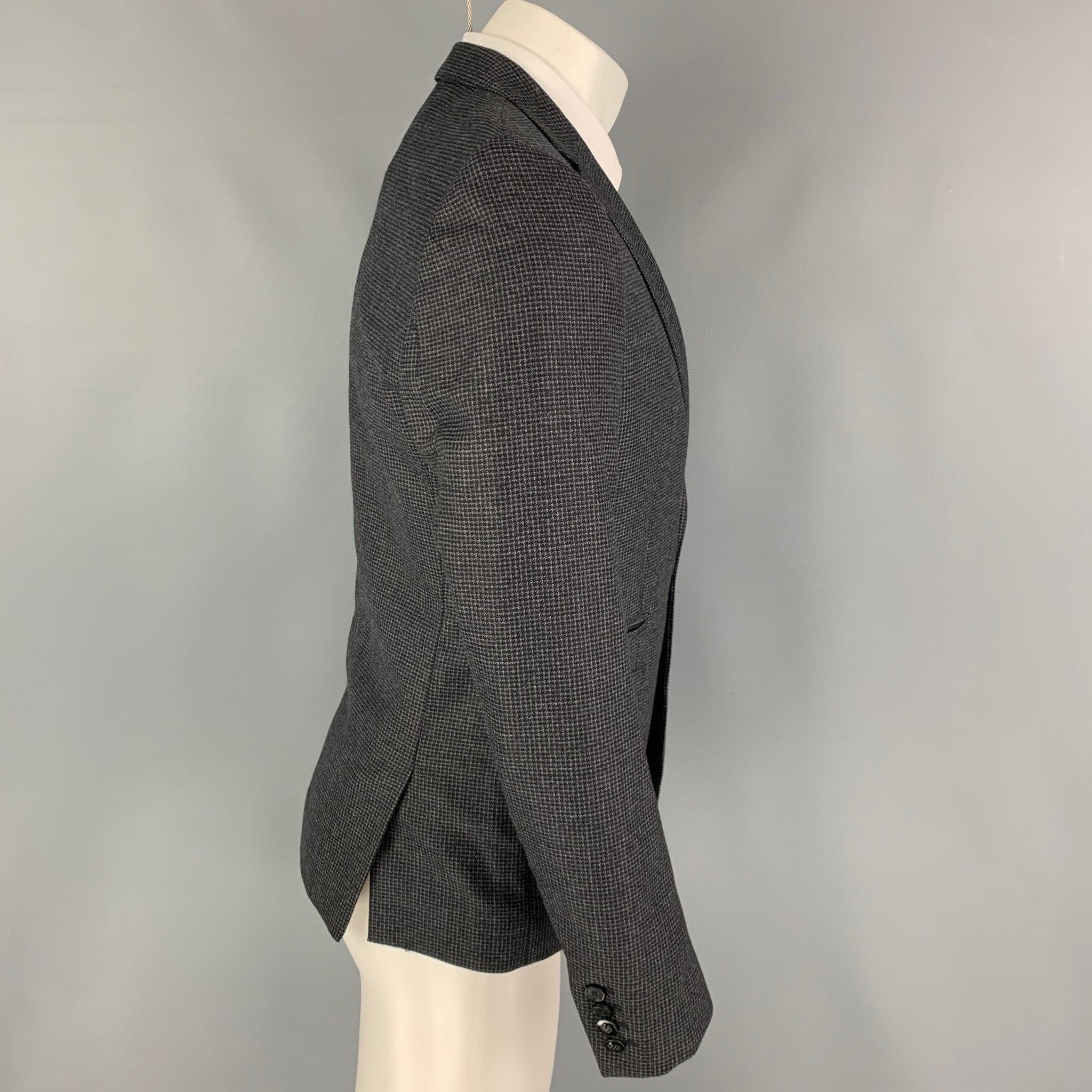 THE KOOPLES sport coat comes in a charcoal grey grid wool with a full liner featuring a notch lapel, flap pockets, double back vent, and a double button closure.
Excellent
Pre-Owned Condition. 

Marked:   46 

Measurements: 
 
Shoulder: 17 inches