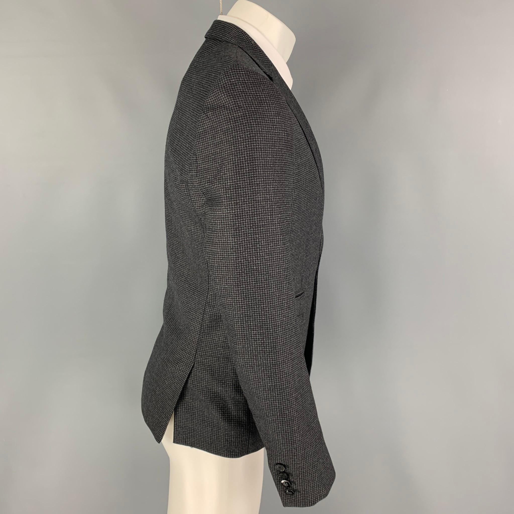 THE KOOPLES sport coat comes in a charcoal grey grid wool with a full liner featuring a notch lapel, flap pockets, double back vent, and a double button closure. 

Excellent Pre-Owned Condition.
Marked: 46

Measurements:

Shoulder: 17 in.
Chest: 36