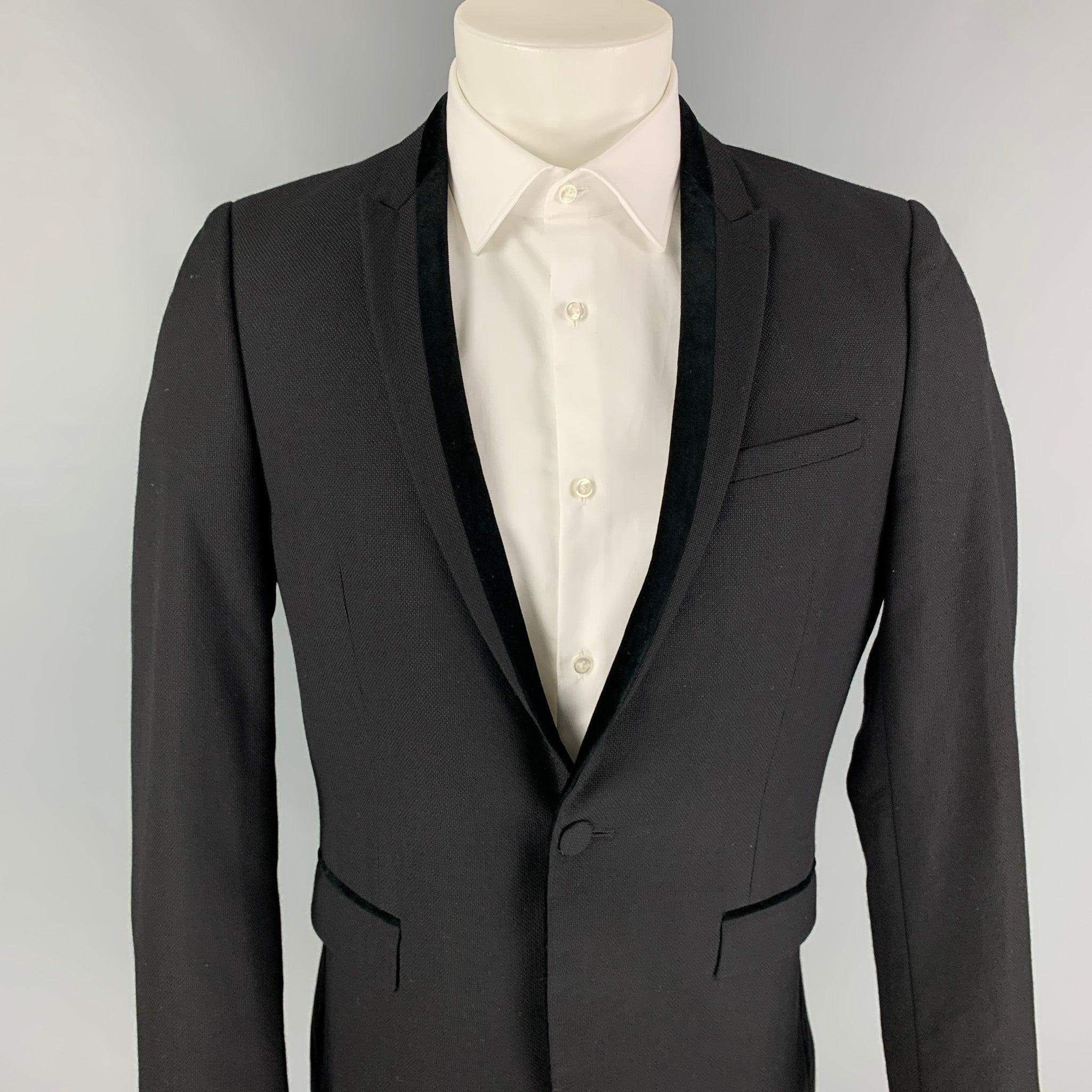 THE KOOPLES sport coat comes in a black woven wool with a full liner featuring a peak lapel, velvet trim, double back vent, flap pockets, and a single button closure.
Very Good
Pre-Owned Condition. 

Marked:   48  

Measurements: 
 
Shoulder: 17