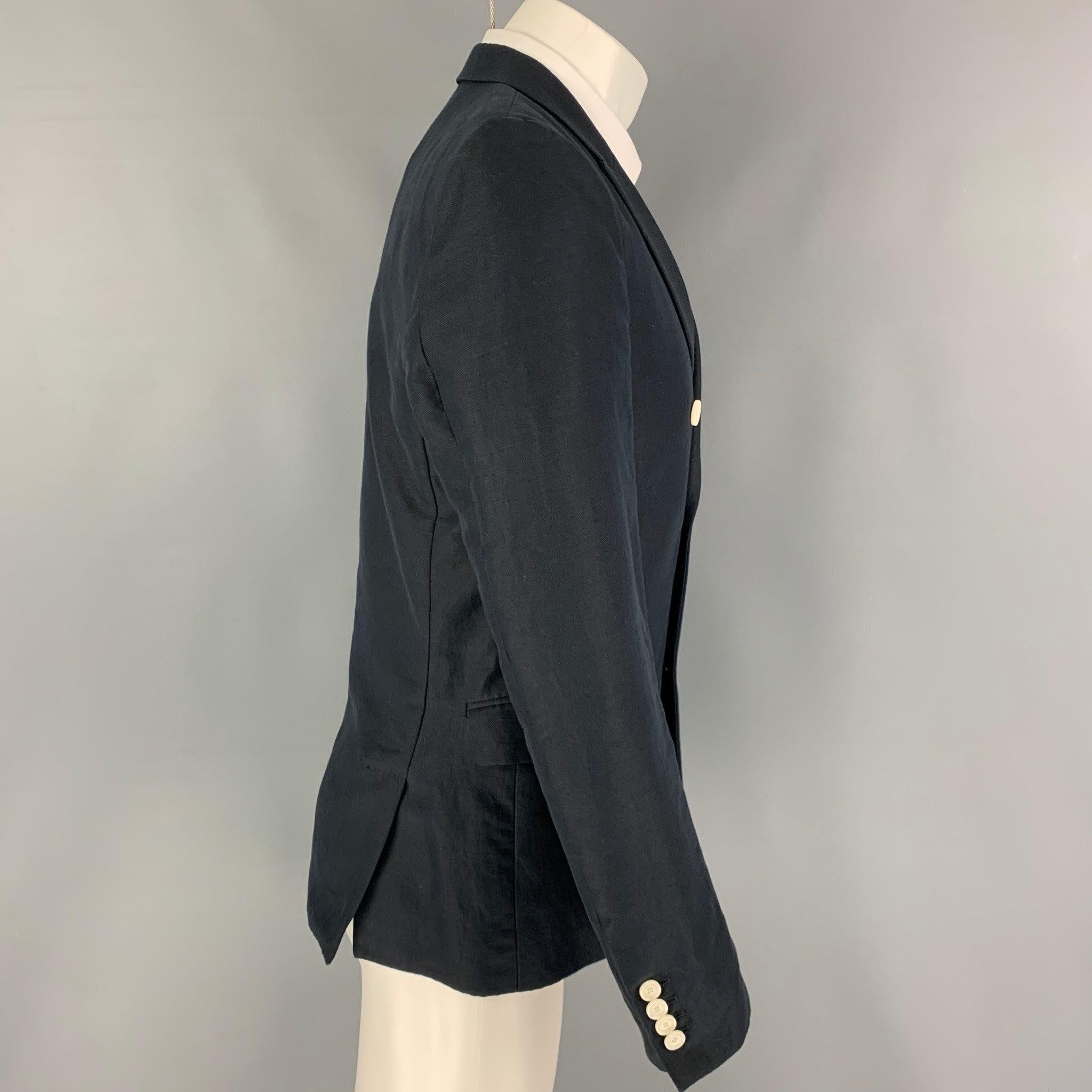 THE KOOPLES sport coat comes in a navy cotton / linen with a half liner featuring a peak lapel, flap pockets, double back vent, double breasted closure.
Excellent
Pre-Owned Condition. 

Marked:   48 

Measurements: 
 
Shoulder: 16 inches Chest: 38