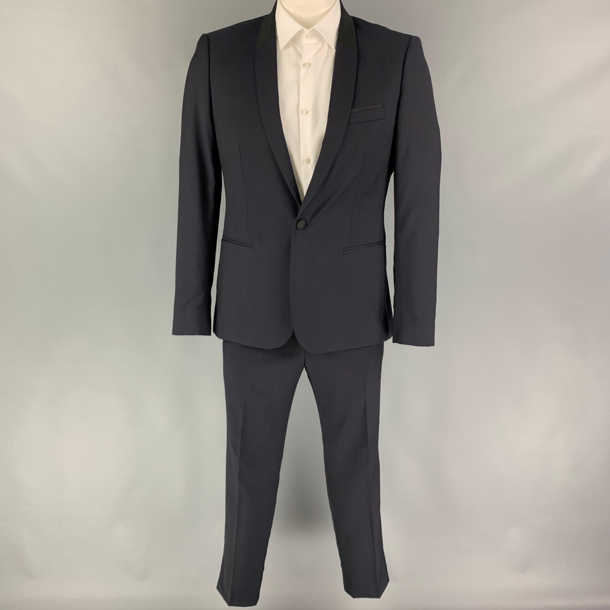 THE KOOPLES suit comes in a navy & black herringbone wool / mohair with a full liner includes a single breasted, single button sport coat with a shawl collar and matching flat front trousers.

Excellent Pre-Owned Condition.
Marked: