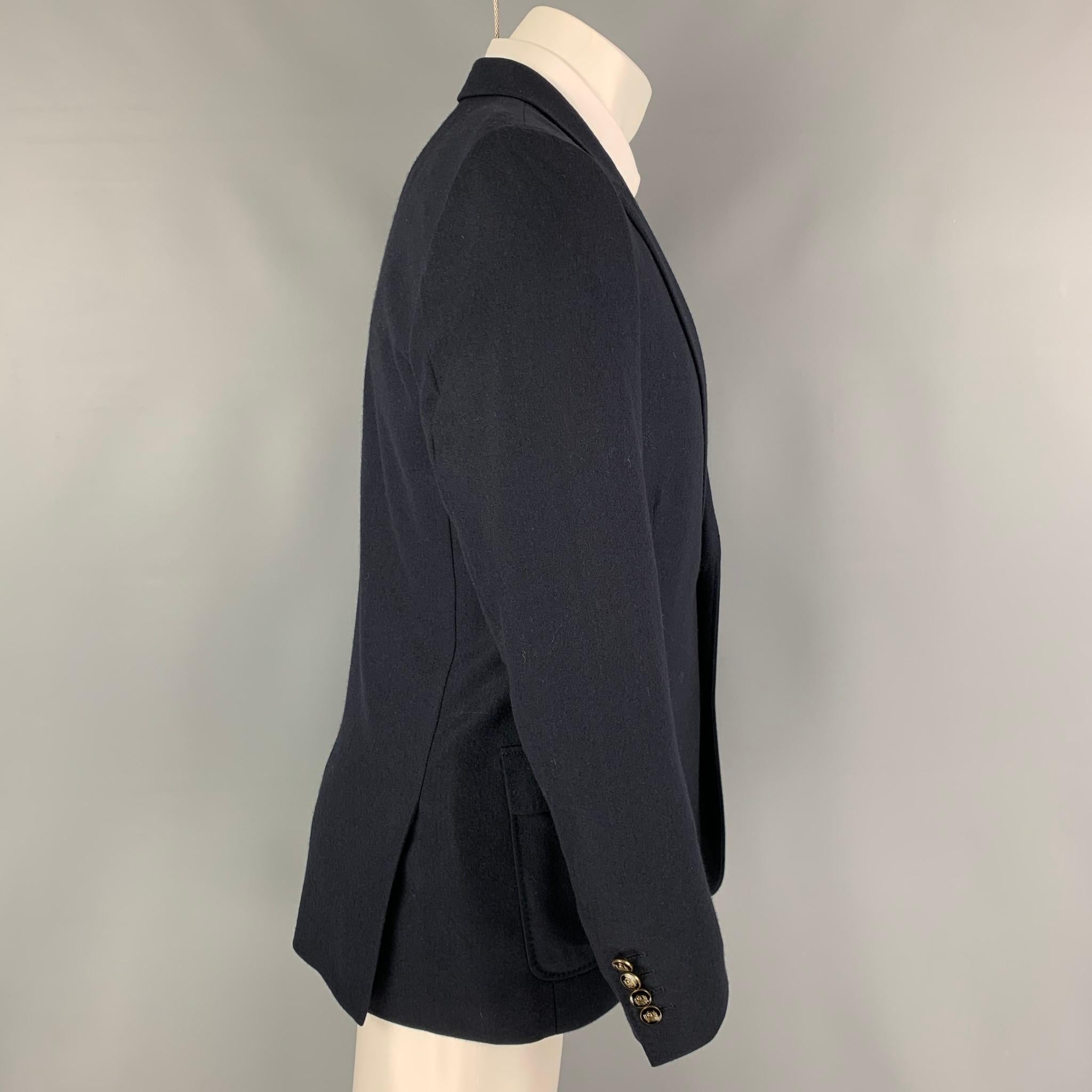 THE KOOPLES sport coat comes in a navy cashmere with a full liner featuring a peak lapel, flap pockets, double back vent, and a double button closure. 

Excellent Pre-Owned Condition.
Marked: 50

Measurements:

Shoulder: 17 in.
Chest: 40 in.
Sleeve: