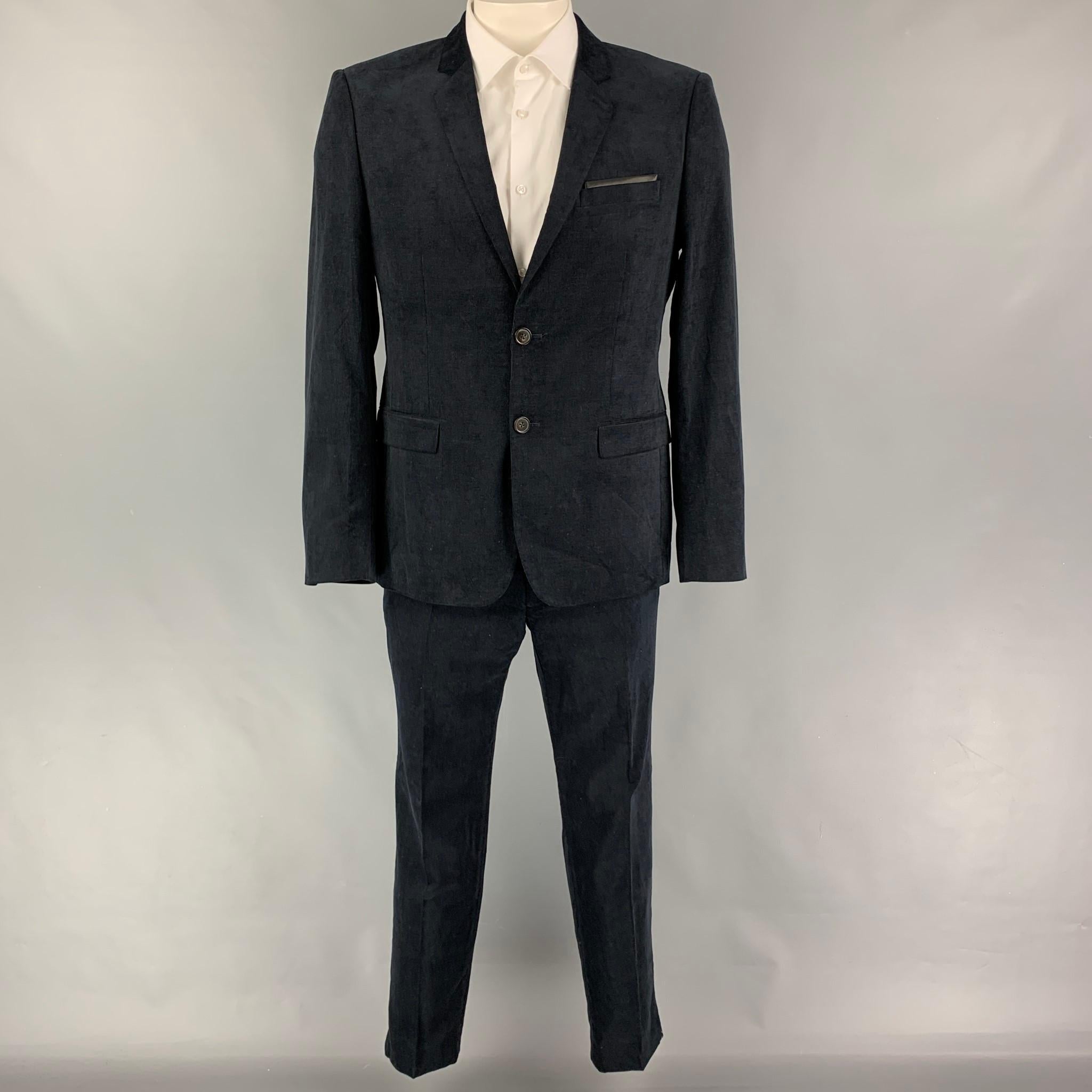 THE KOOPLES suit comes in a navy corduroy cotton with a full liner and includes a single breasted, double button sport coat with a notch lapel and matching flat front trousers. Includes tags.

Very Good Pre-Owned Condition.
Marked: 52
Original
