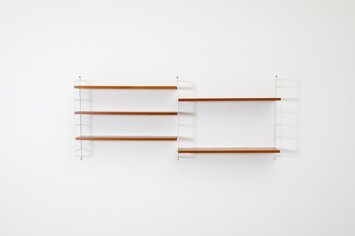 Classic Scandinavian Design String shelving system designed by Nisse Strinning for String, 1949. This two section shelving system has three white wire risers and five adjustable teak shelves. A functional and stylish shelving system with great style