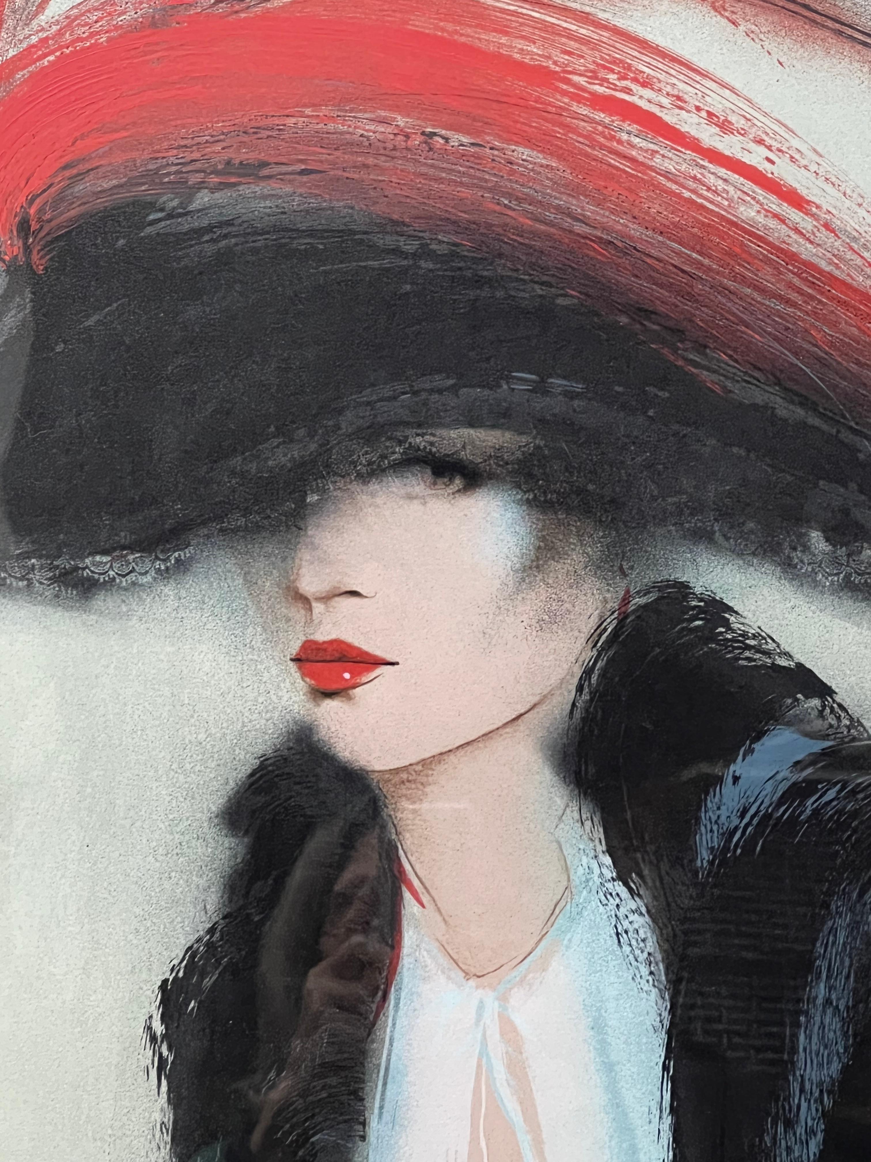 This color lithograph is by Victoria Montesinos. It features an elegant lady from early 20th Century holding a rose in her right hand. The artist matches the red of her lipstick with the color of the rose. The large hat covering almost her eyesight