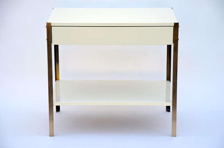 Pair of 'Laque' minimalist ivory lacquer and brass night stands by Design Frères.

Bottom shelf height: 6 in.