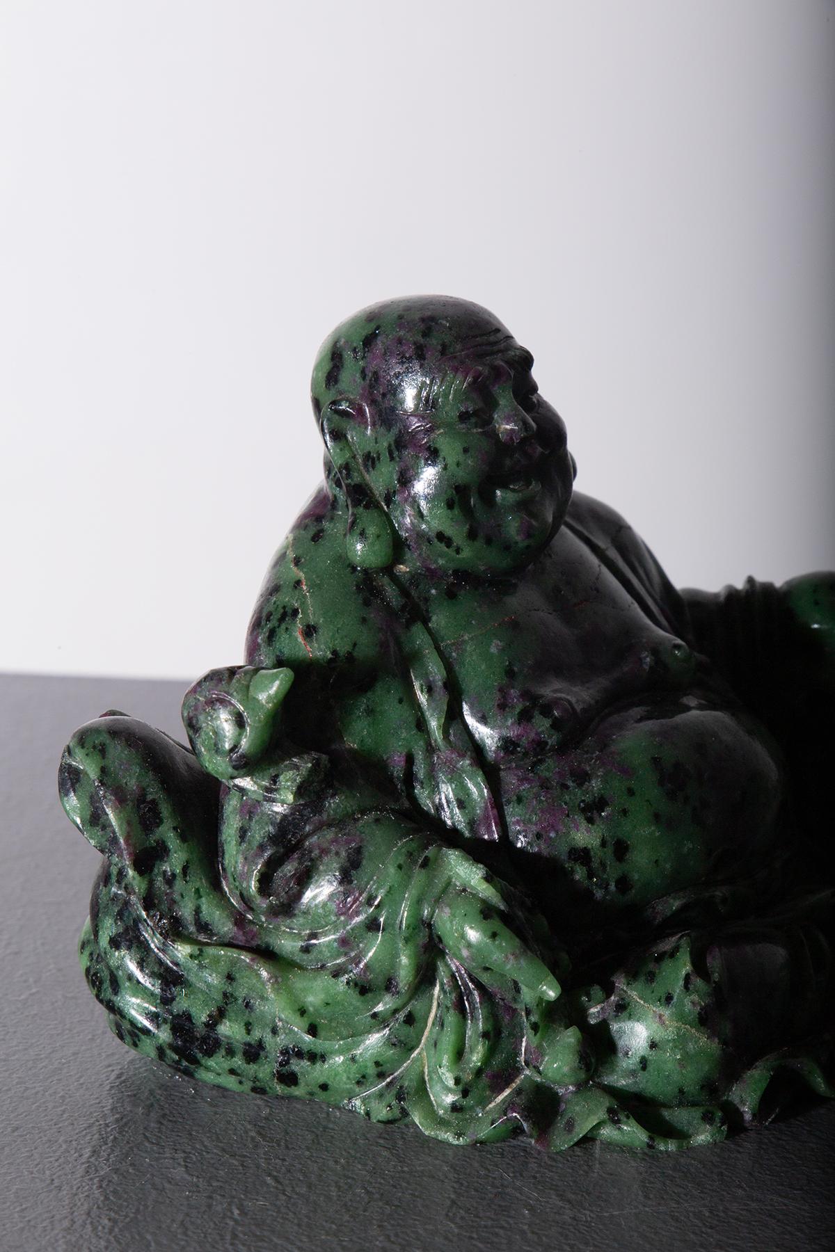Immerse yourself in the world of serenity and abundance with this exquisite Budai, the Laughing Buddha statue. Crafted from a uniquely patterned green material, this statue captures the spirit of Budai, a beloved figure in Buddhist culture known for