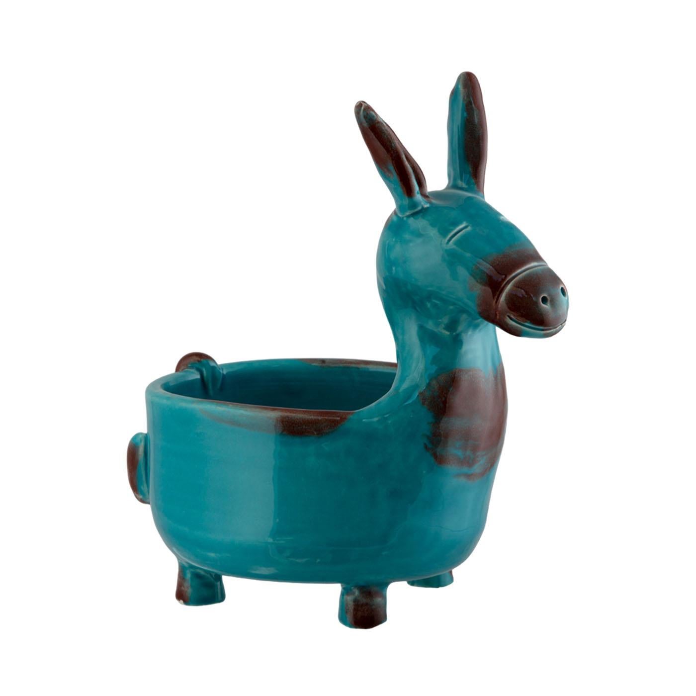 The charming Little Donkey, fashioned from hand-worked clay and fired in a second round with vibrant colored crystals, embodies versatility. This figurative vase serves multiple purposes as a plant or object holder and occasionally doubles as a
