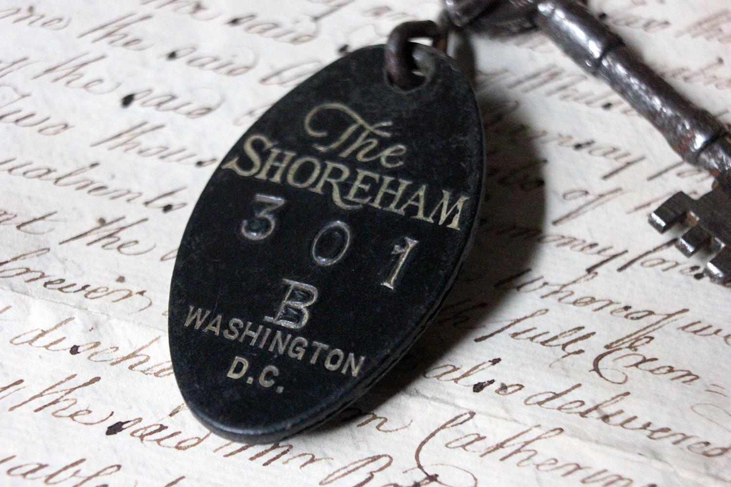 The mis-laid 1930s period part-barrel shafted iron key marked ‘Oakley Brighton’, to a black bakelite fob with beautifully etched and punched script for The Shoreham 301 B Washington D.C. with the reverse stating ‘Drop in any mail box unsealed,