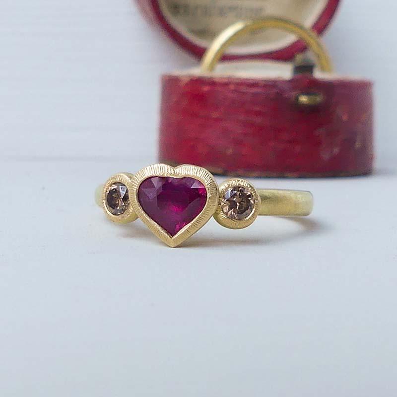 The Mab ethical engagement ring centres on an ethical ruby heart of 0.63 carats and two chocolate diamonds set into 18ct Fairmined gold.

The band is half round and measures 2.3 x 1.9 mm 

With a dreamy, romantic quality, she’s one-of-a-kind and