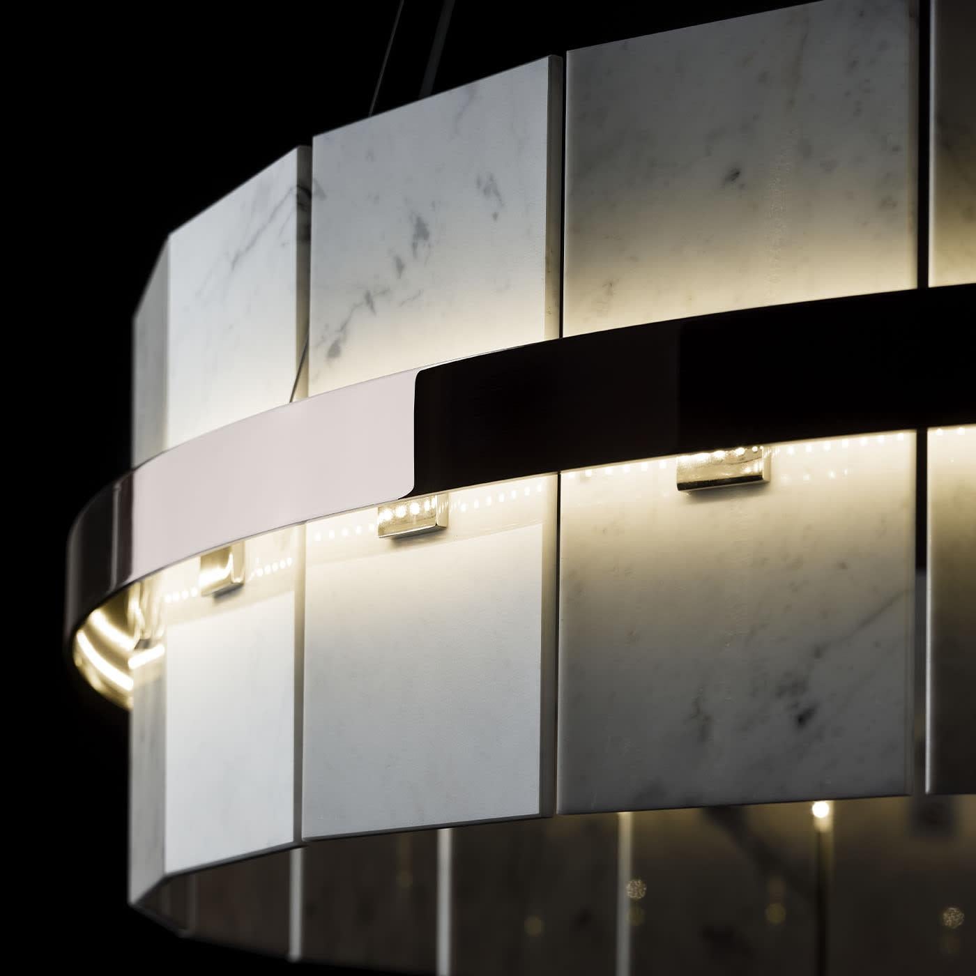 A contemporary design of timeless value, this pendant lamp will make for an iconic accent to a living room, entryway, or bedroom decor of modern inspiration. Crafted of brass, it features a circular profile enriched with white Carrara marble tiles,