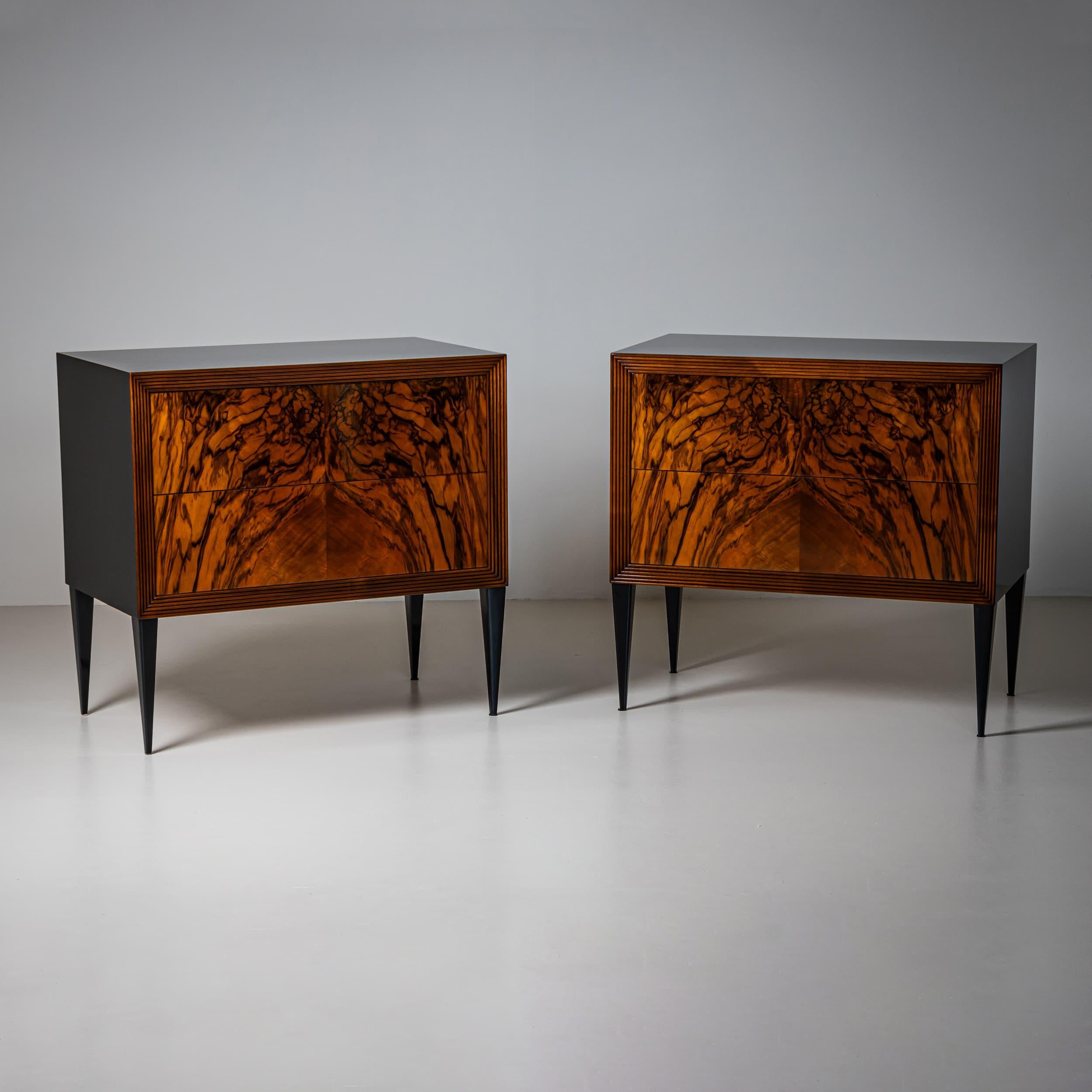 Pair of modern chests of drawers in walnut with ebonized tapered square legs, sides, and tops. The chests feature two drawers. The multiple stepped moldings around the drawer fronts beautifully highlight the dramatically bookmatched veneer. The