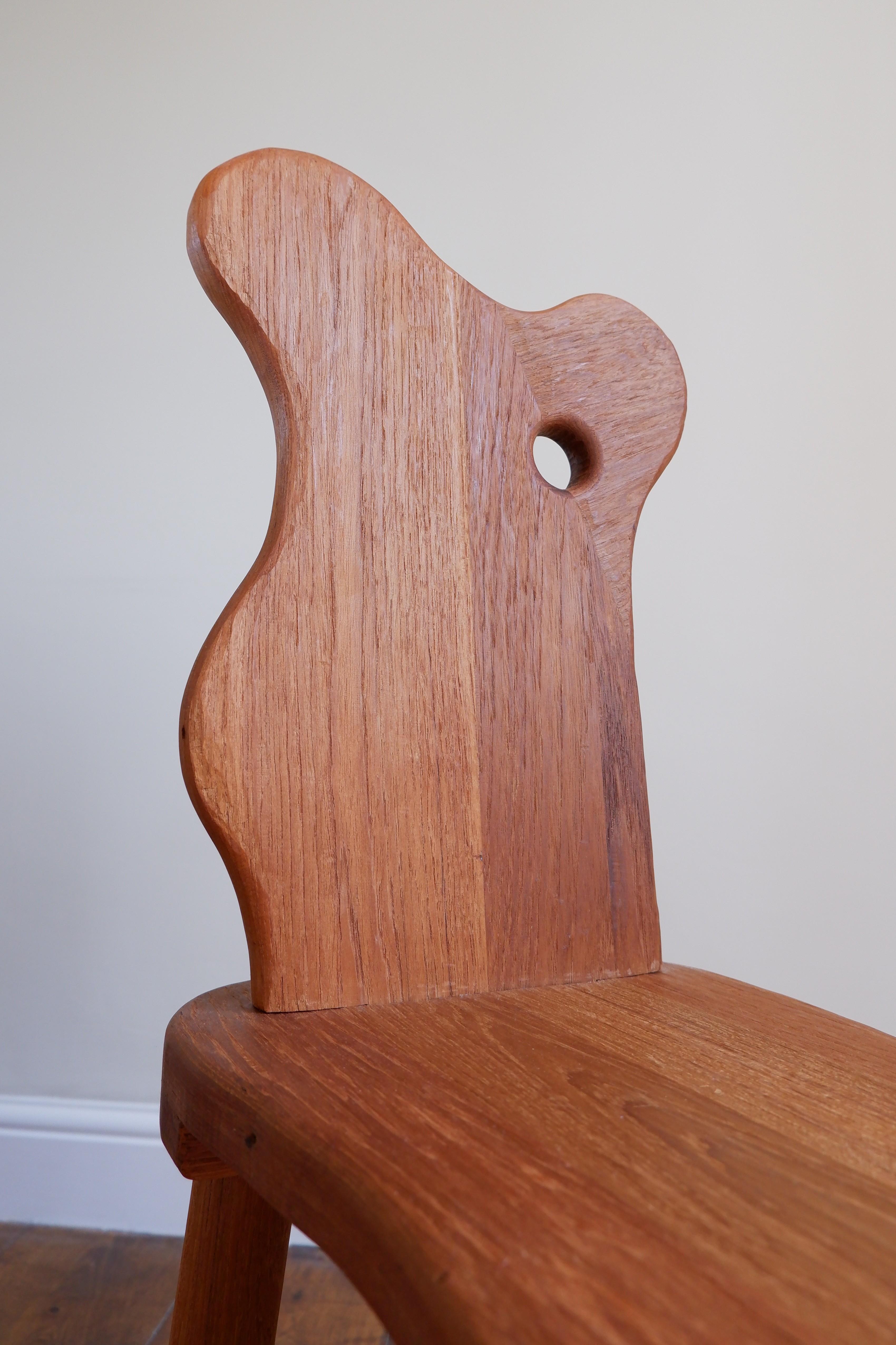Tabouret de traite en Sapele 430 récupéré, avec dossier incurvé et détails sculptés.