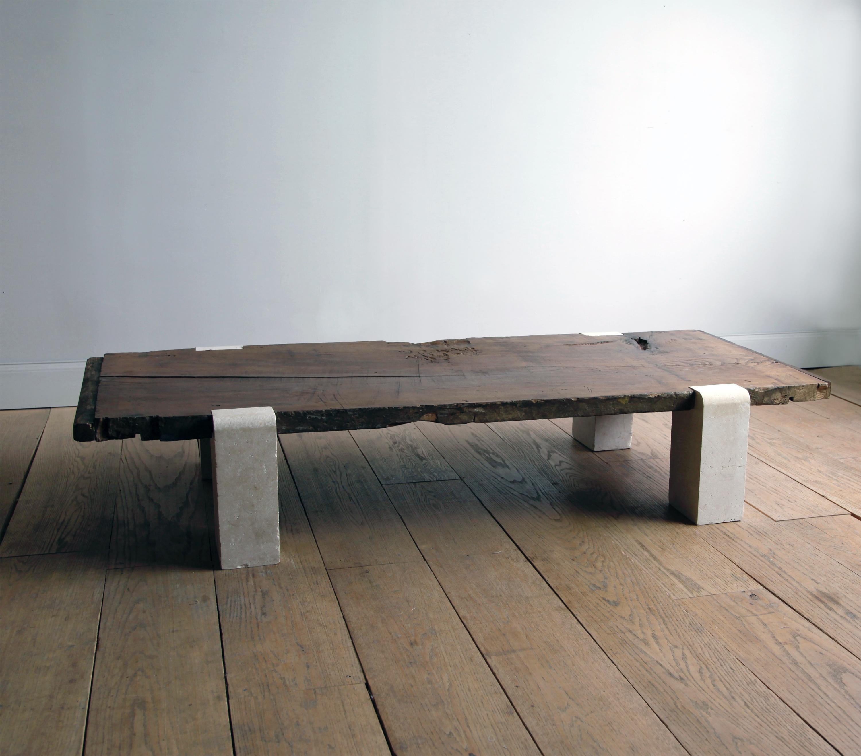 This long, low coffee table can double as a bench or daybed. The wood top is a rare, single slab of antique Belgian old growth walnut that expresses not only its organic essence but the years of use which have tempered its surface. It sits securely