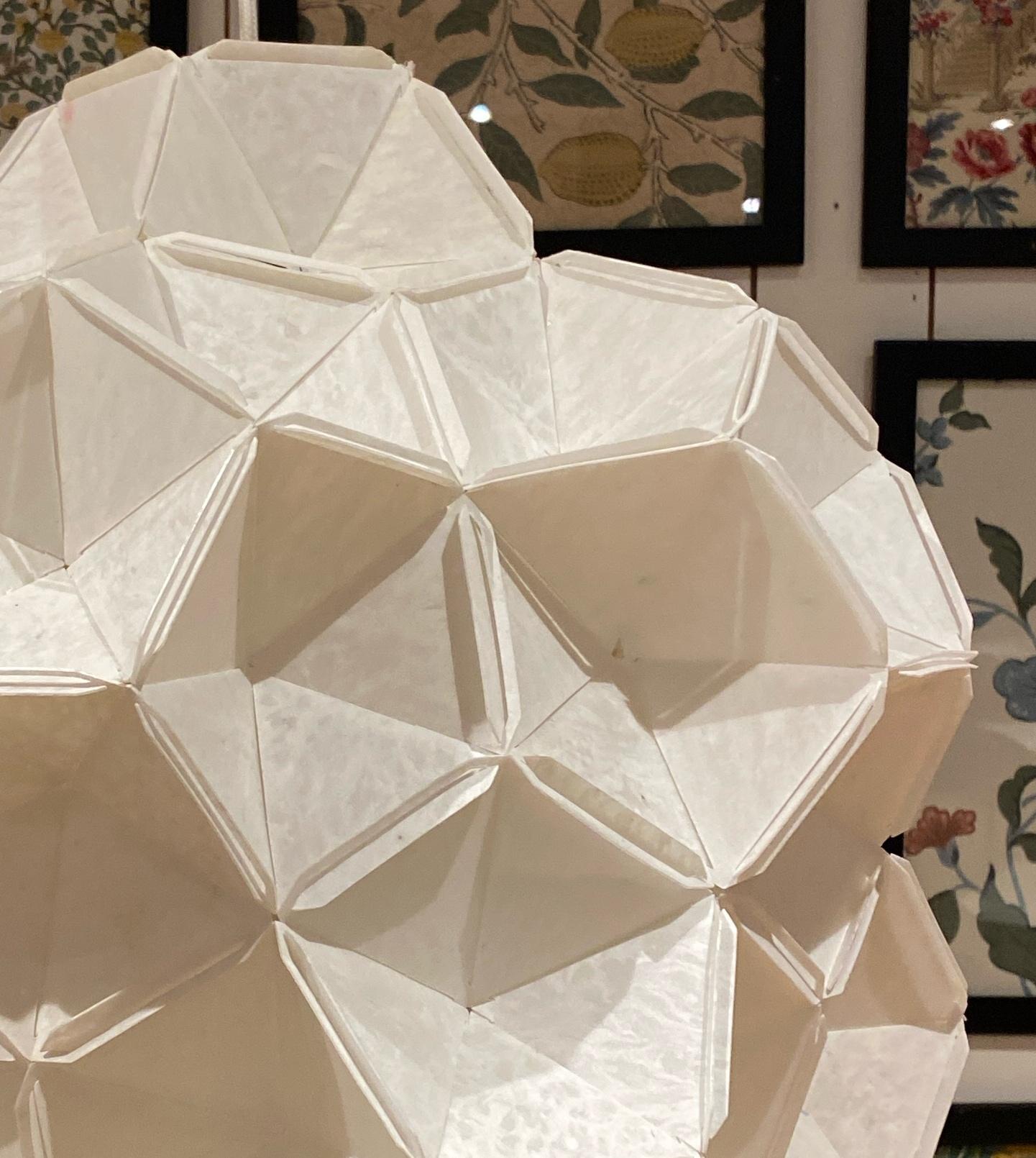 La scultura luminosa Moona è stata progettata da Jakob Uhlin per By Republiken, una straordinaria creazione artigianale realizzata con carta e plastica riciclata. Questa lampada a sospensione presenta un esterno in carta di seta supportato da un