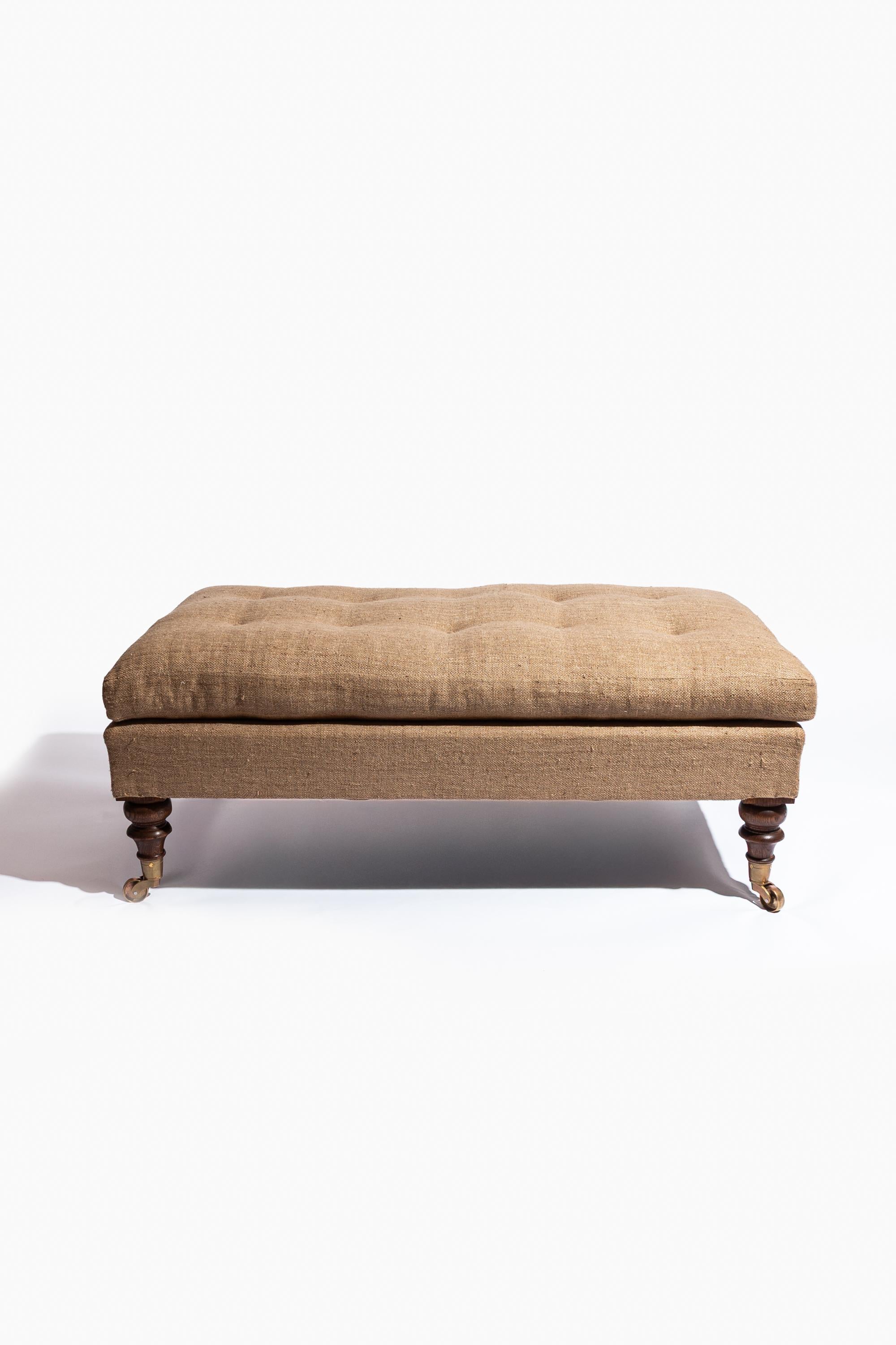 The Moreton Footstool, modelled on the design of late 19th Century stools by Howard & Sons, is traditionally hand made in England to the highest standard. The beech frame is raised on hand turned oak legs and topped with a feather and down tailored