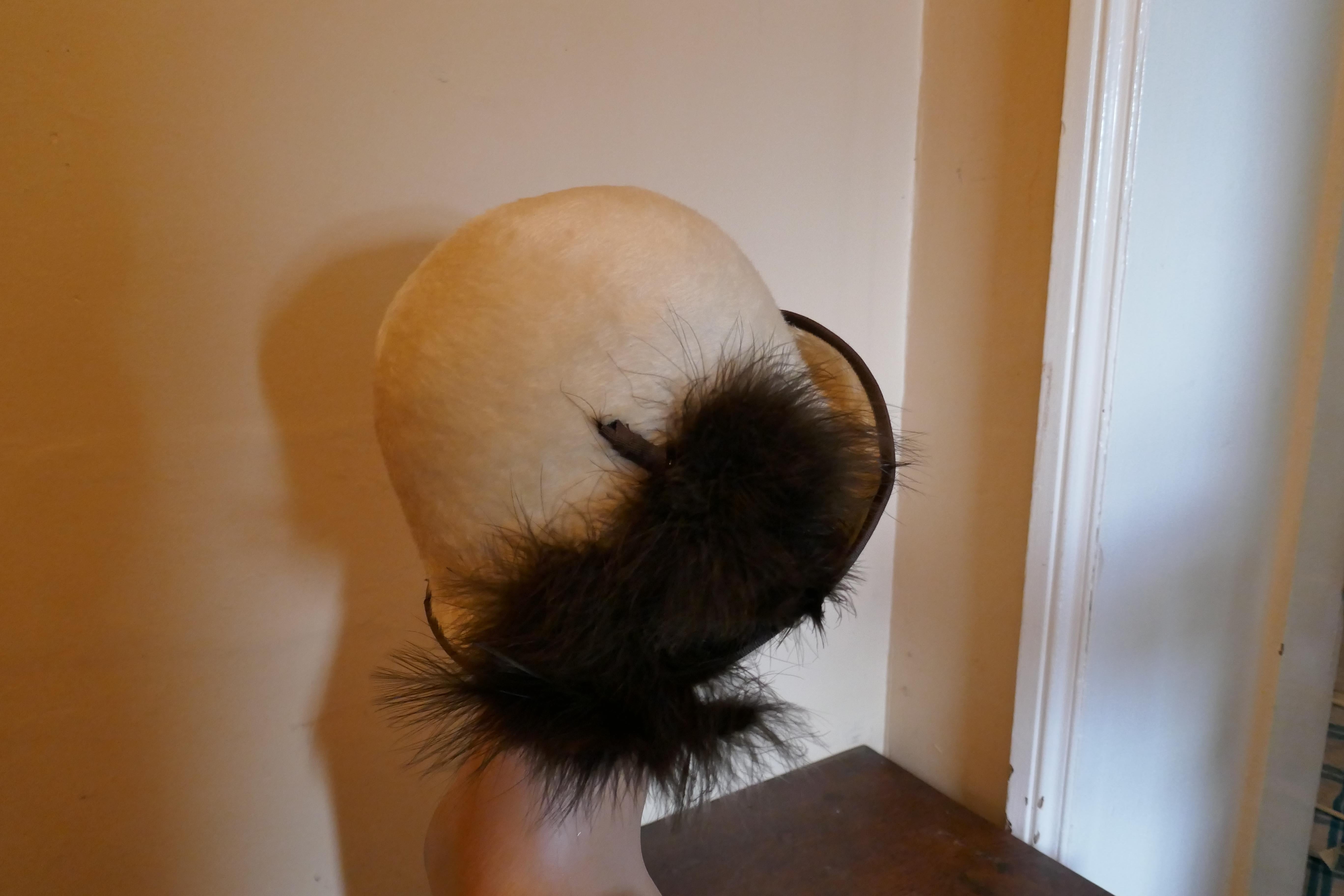 The Most Beautiful 1920s Felt Fur Cloche Hat by Bermona

Superb Soft Fur Fabric Cloche hat classic 1920s Head Hugging Style, an offset up turned brim trimmed with Ostrich Feather

The hat is very fine quality and in good condition, the inside