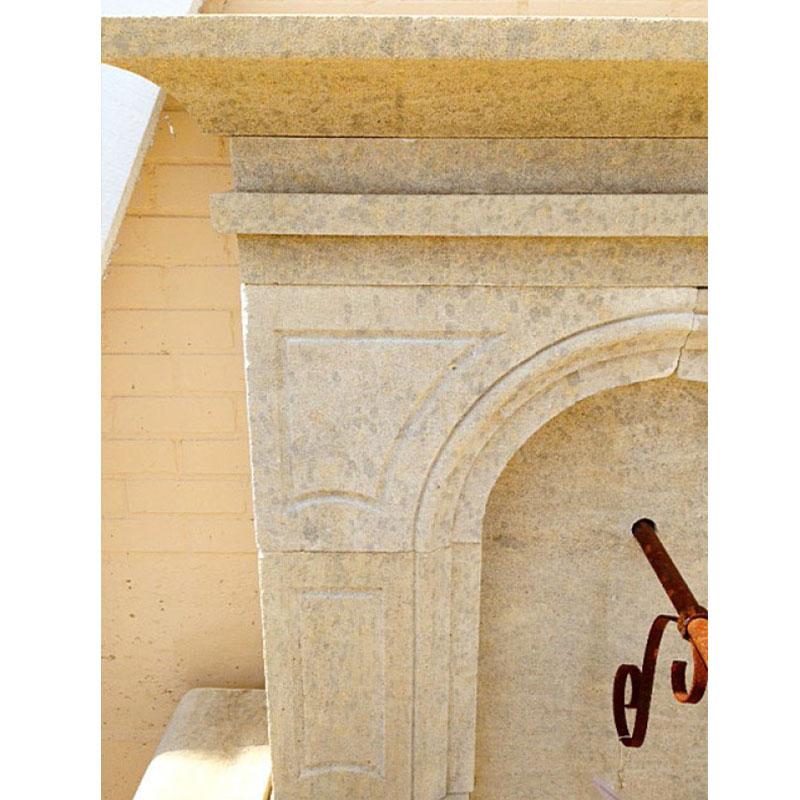 Fontaine murale française en pierre calcaire sculptée à la main, dotée d'un bassin semi-circulaire conçu pour recueillir le trop-plein d'eau. Au centre de la plaque arrière, un trou pré-percé accueille un bec verseur, permettant à l'eau de s'écouler